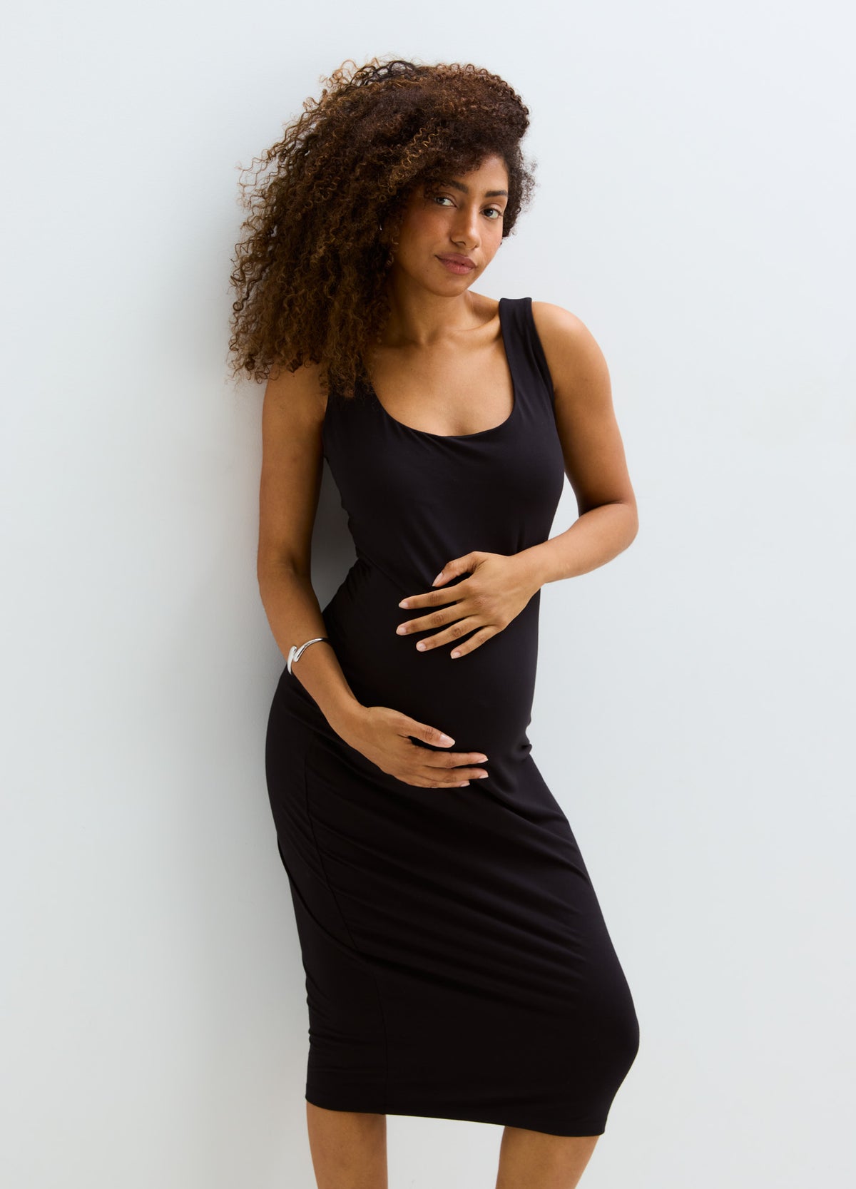 Black sleeveless maternity bodycon tank dress with scoop neckline and knee-length hem.