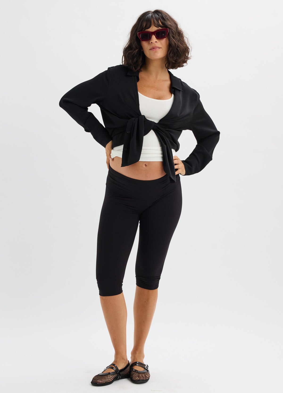 Black cropped maternity leggings with a high, supportive waistband in stretchy fabric.