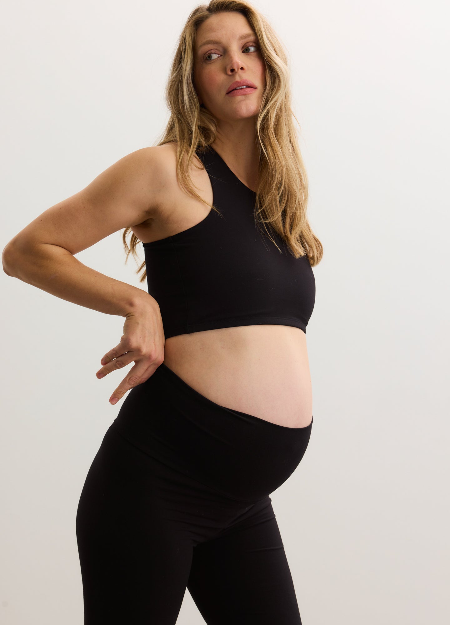 Black ribbed maternity crop racer tank with a high neckline and sleeveless design.