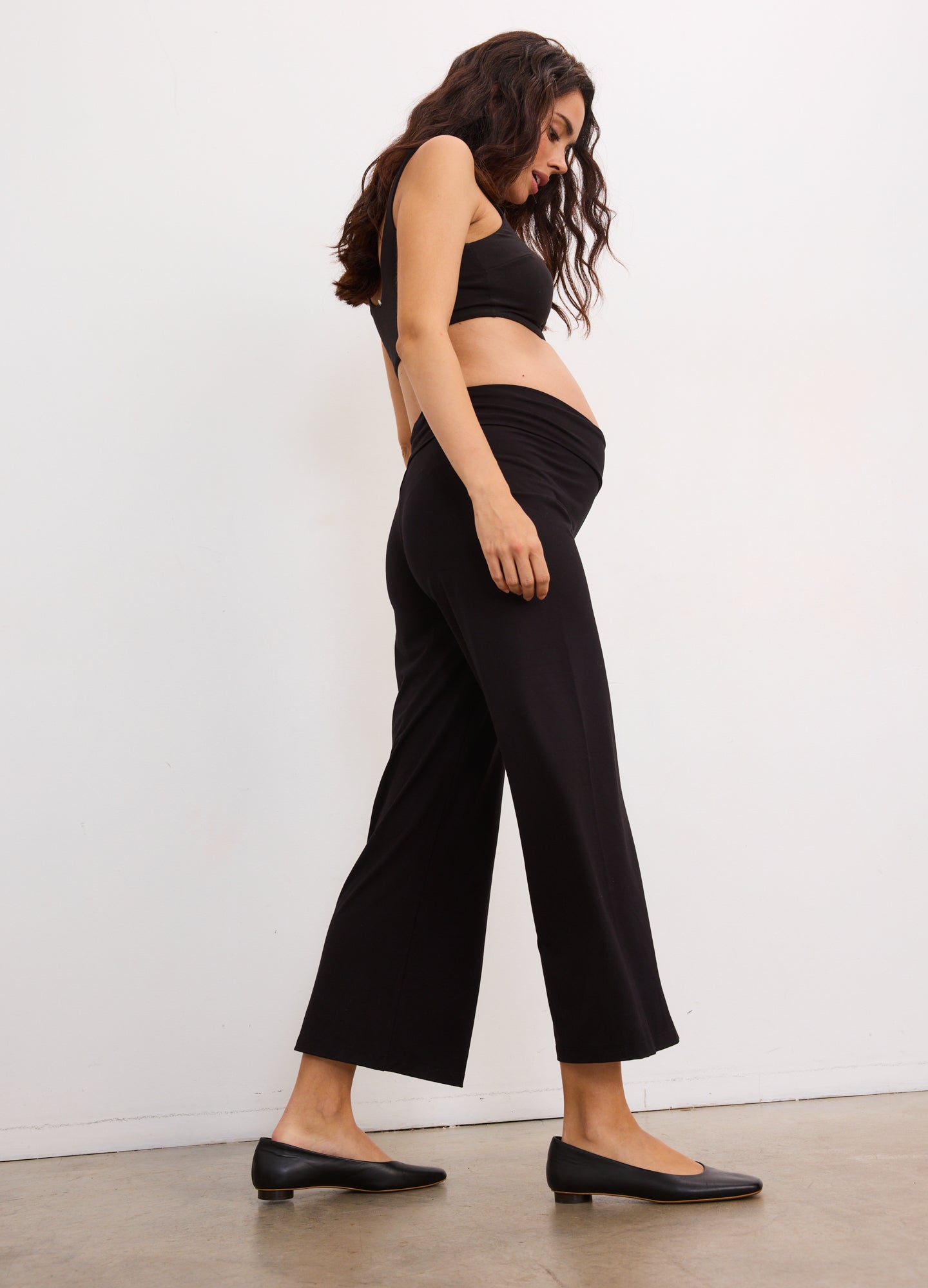 Black wide-leg maternity pants with high, stretchy waistband designed to fit over baby bump.