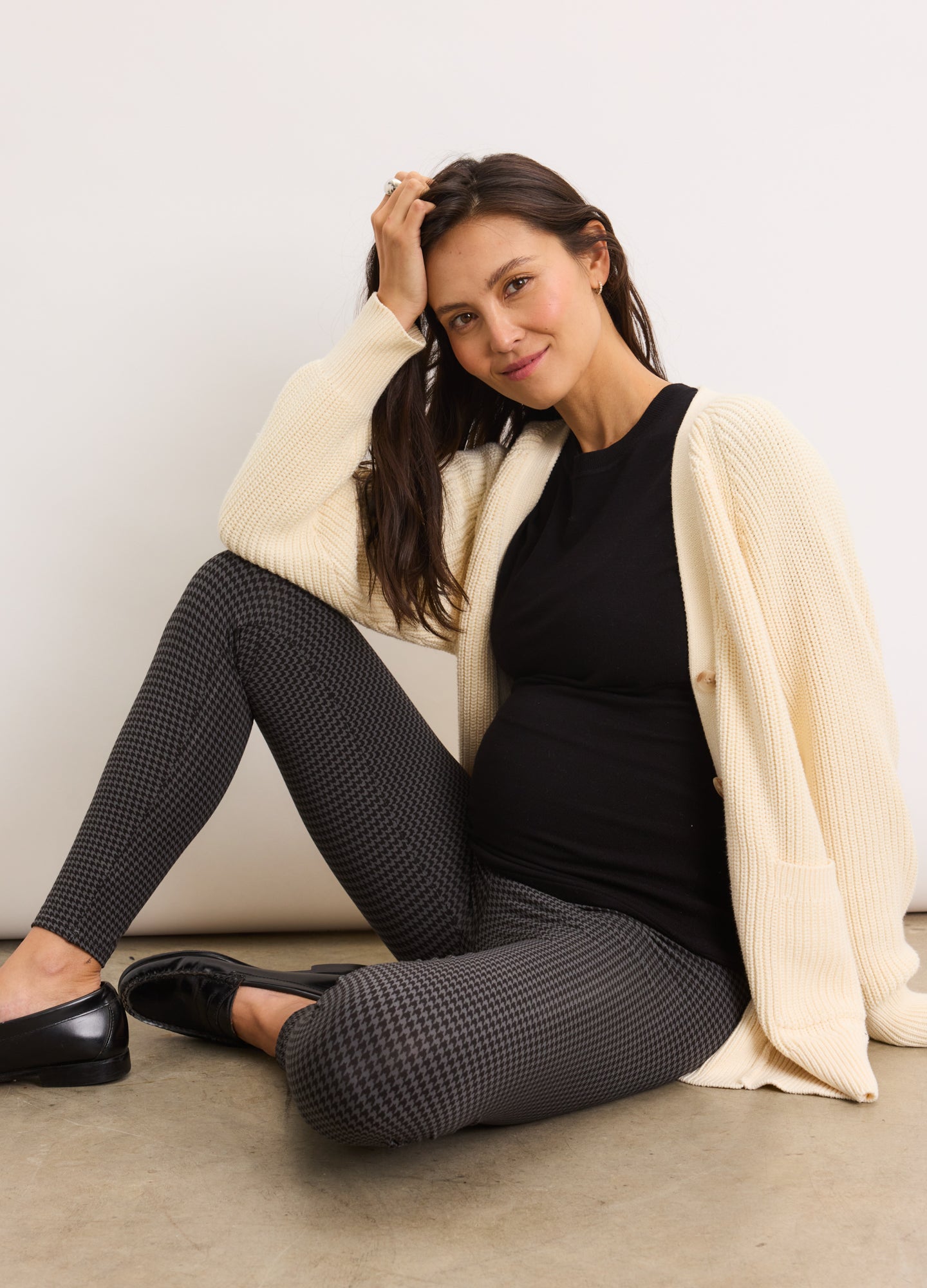 Maternity leggings in black with subtle chevron pattern, high stretch fabric, paired with cream cardigan and black top.