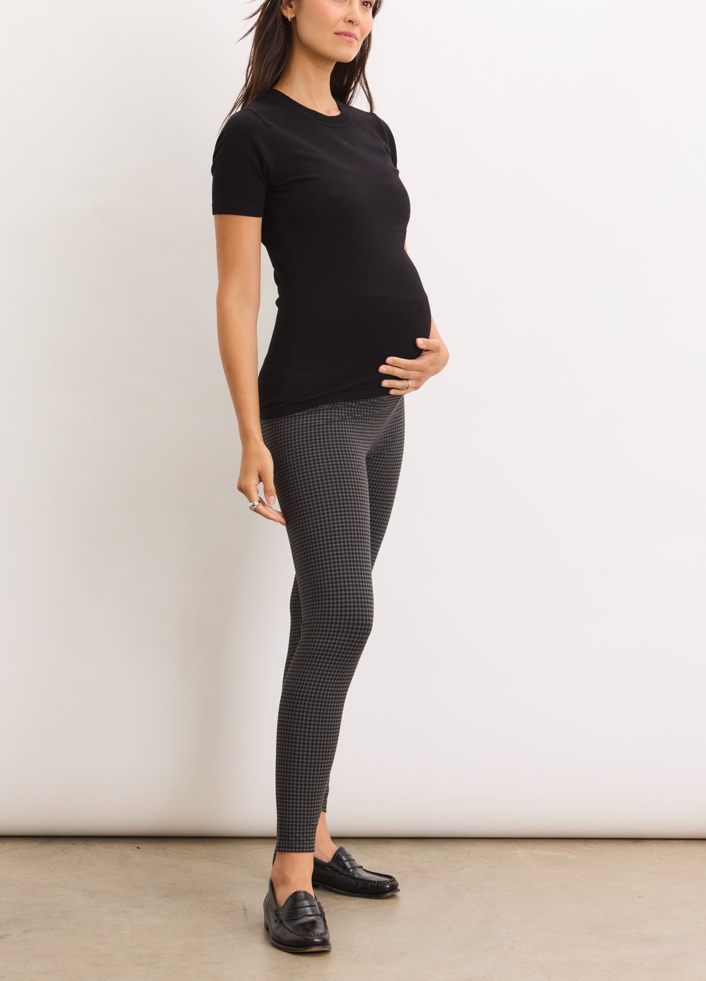 Dark gray maternity leggings with high waistband, paired with fitted black short-sleeve top and black flats.