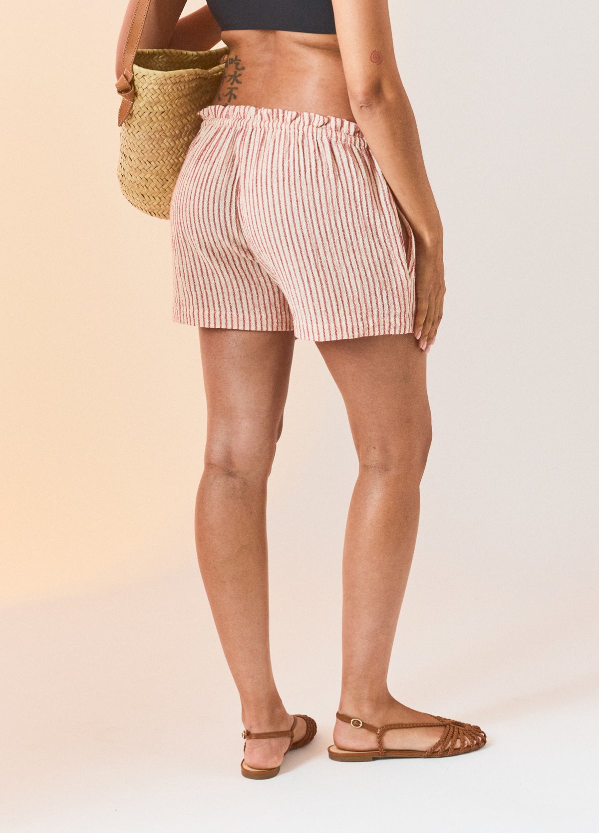 Pink and white striped maternity beach shorts with elastic waistband and relaxed fit.