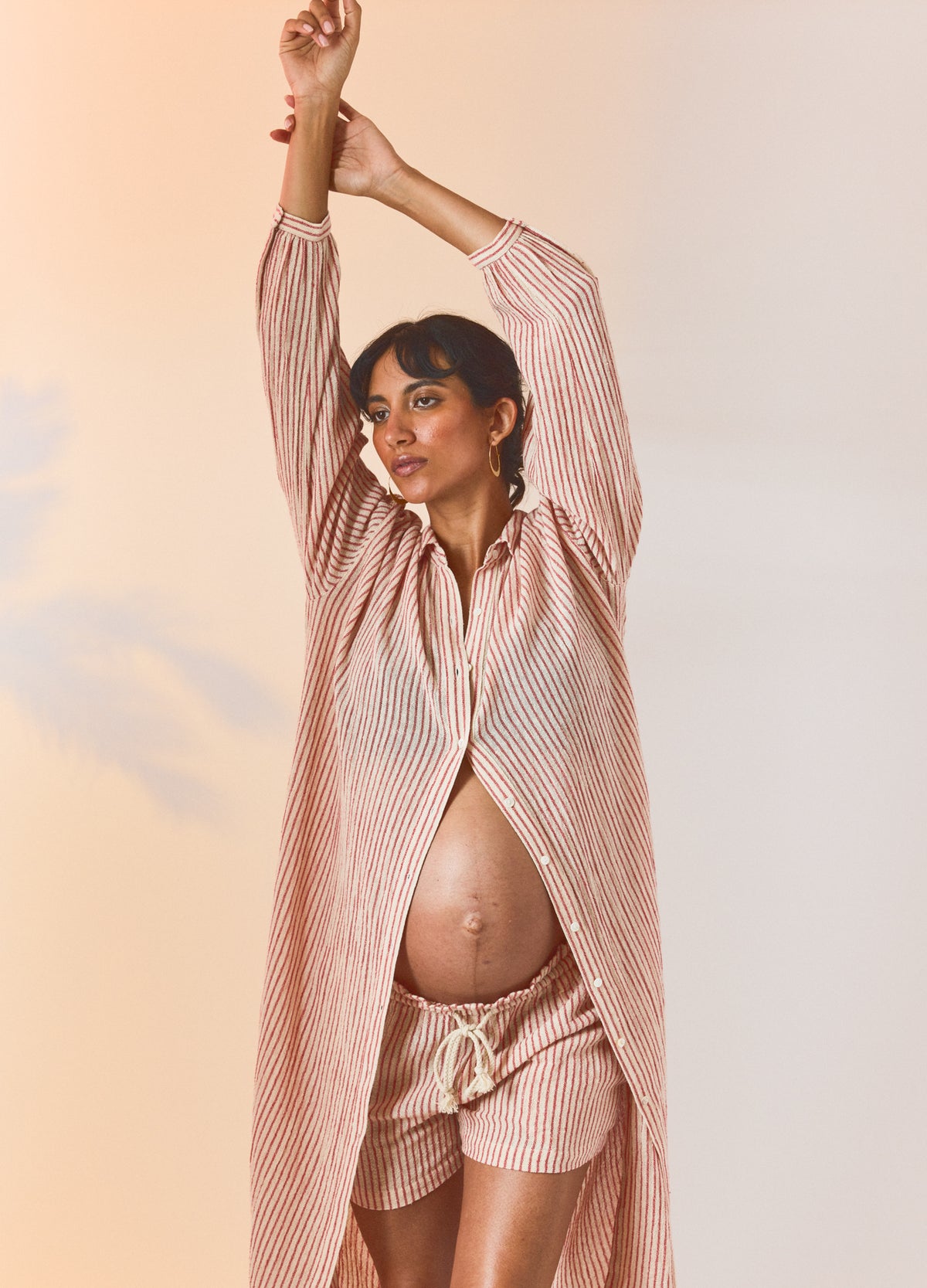 Red and natural striped maternity shirt dress with long sleeves, open front, styled on pregnant model.