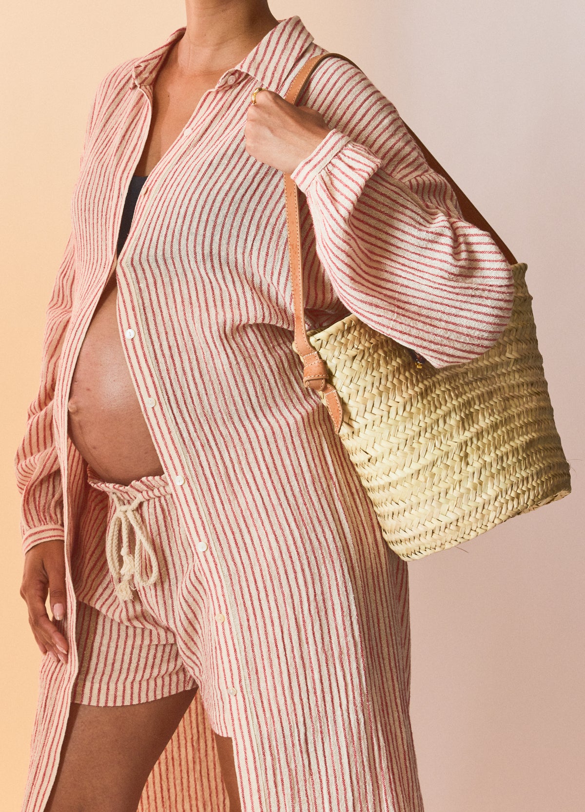 Red and natural striped maternity shirt dress with long sleeves and front buttons, styled over matching shorts on a pregnant .