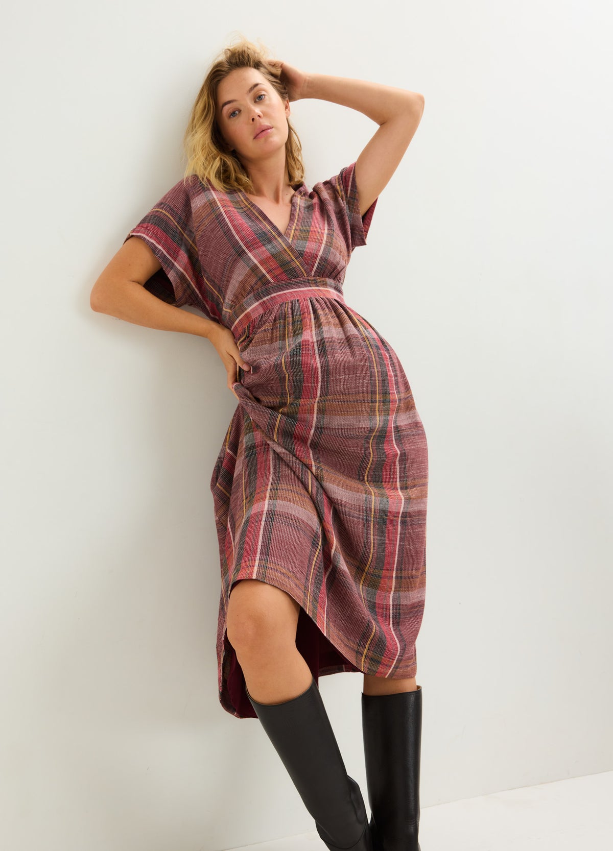 Maternity plaid midi dress with short sleeves, V-neck, and side slit in warm autumn tones.