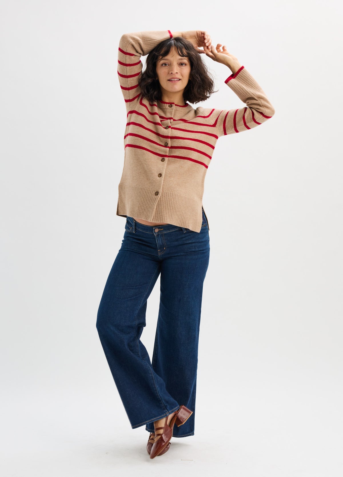 Beige and red striped maternity cardigan with buttons, worn with dark blue wide-leg jeans and brown shoes.
