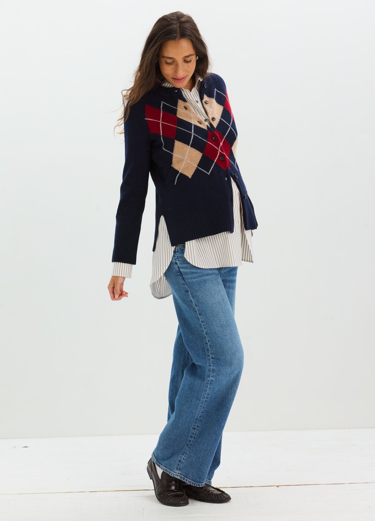 Navy knitted maternity cardigan with red and beige argyle pattern, worn over white blouse and blue jeans.