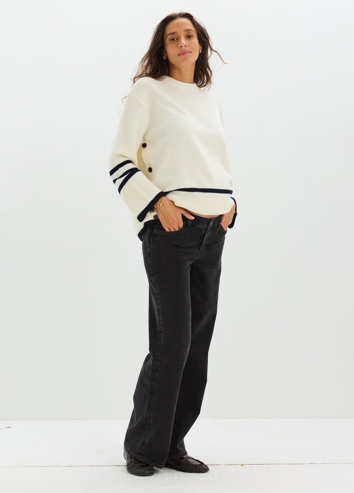 Cream-colored maternity nursing sweater with black stripes on sleeves, relaxed fit, worn with black wide-leg jeans.