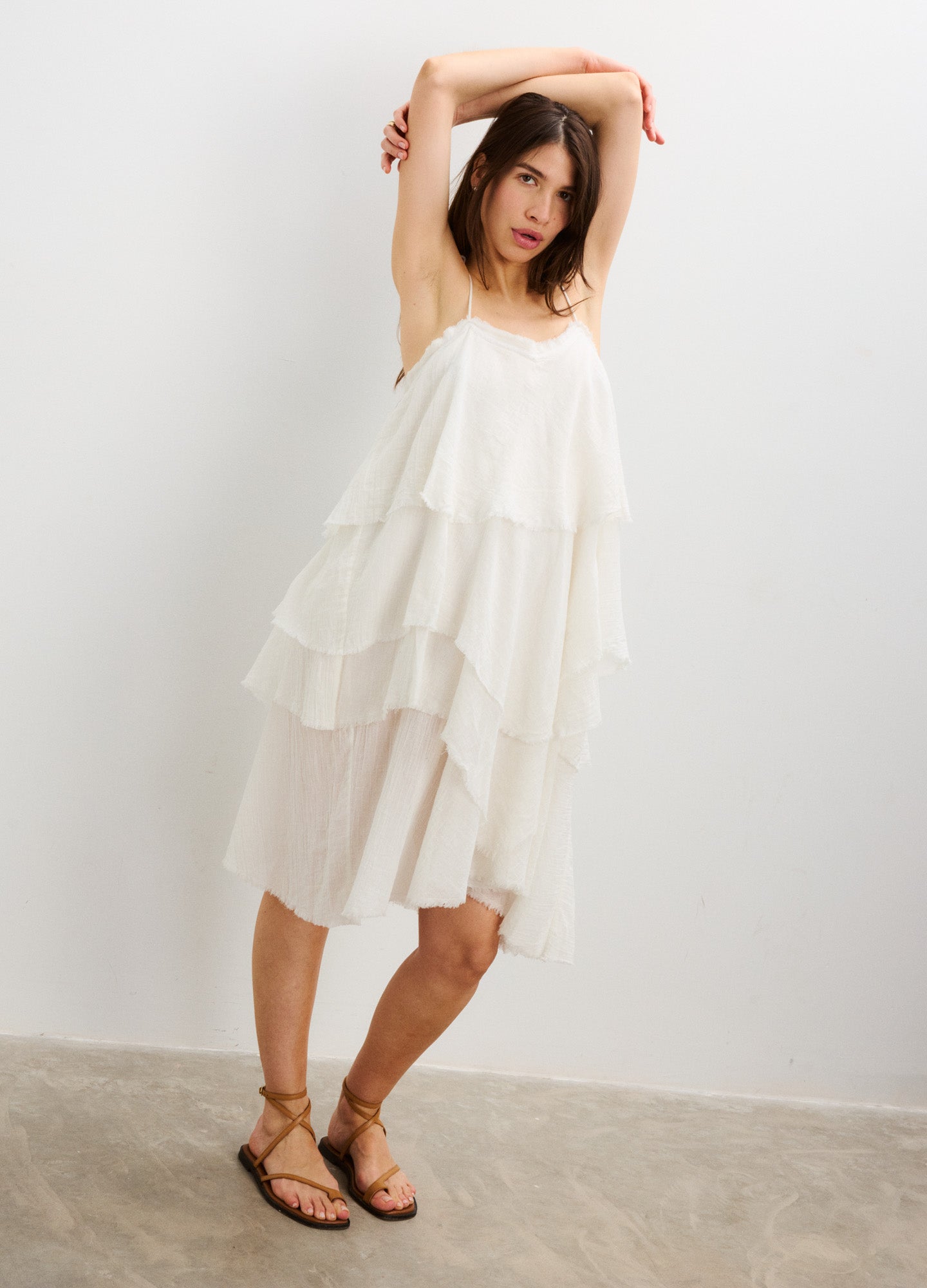 White layered sleeveless maternity dress with loose, flowy fabric and spaghetti straps.