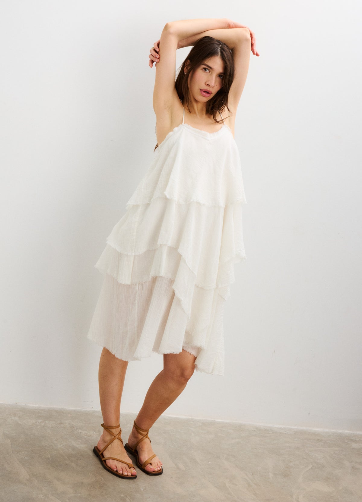 White layered sleeveless maternity dress with loose, flowy fabric and spaghetti straps.