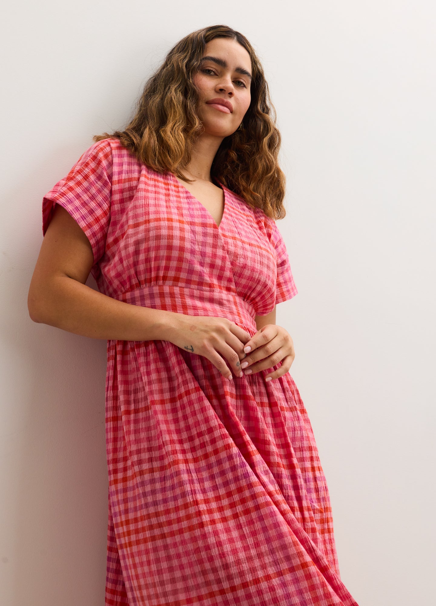 Pink and red plaid maternity dress with short sleeves and a V-neckline, designed for pregnant women.