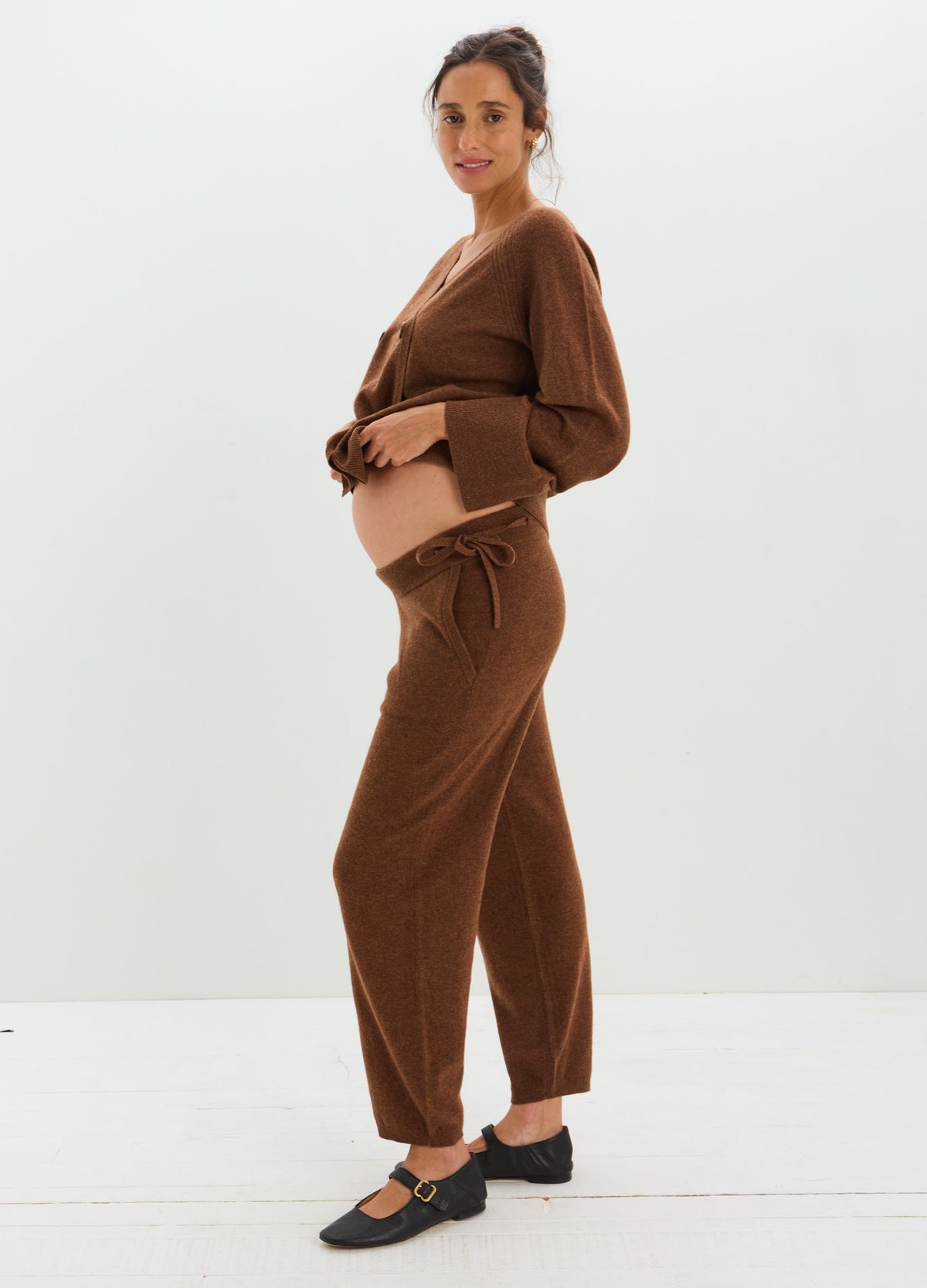 Model wearing relaxed brown cashmere pants with an adjustable drawstring waist and straight, loose legs.