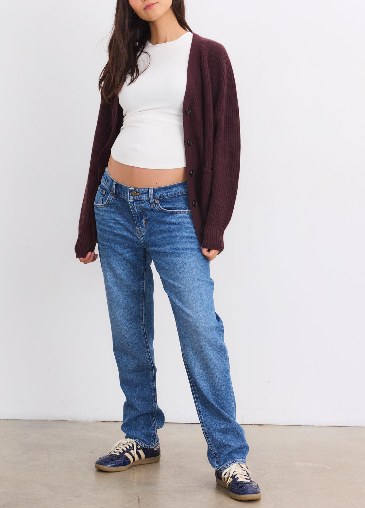 Dark plum cashmere cardigan with relaxed fit and long sleeves layered over white maternity top and blue jeans.