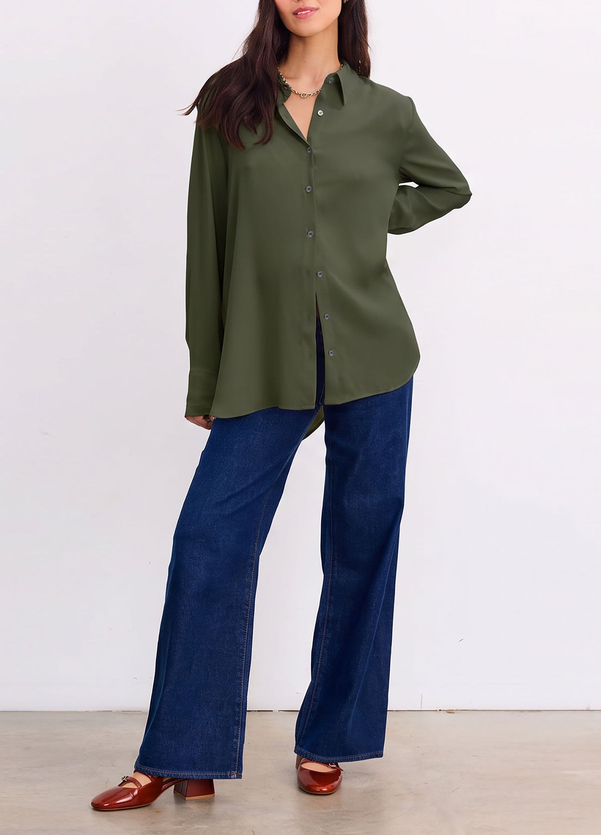 Olive green drapey button-down shirt with a pointed collar and relaxed fit, paired with wide-leg jeans.