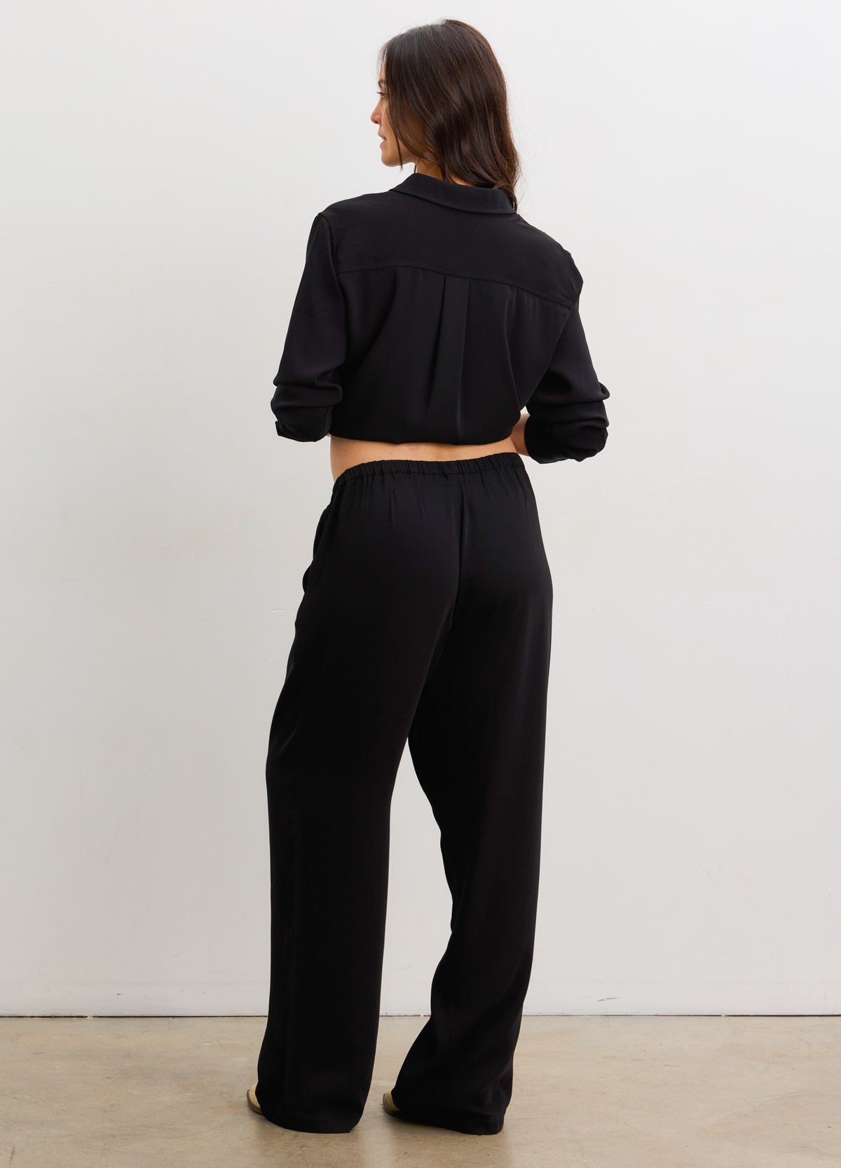 Black maternity pull-on pants with drapey wide legs, designed for pregnant comfort and style.