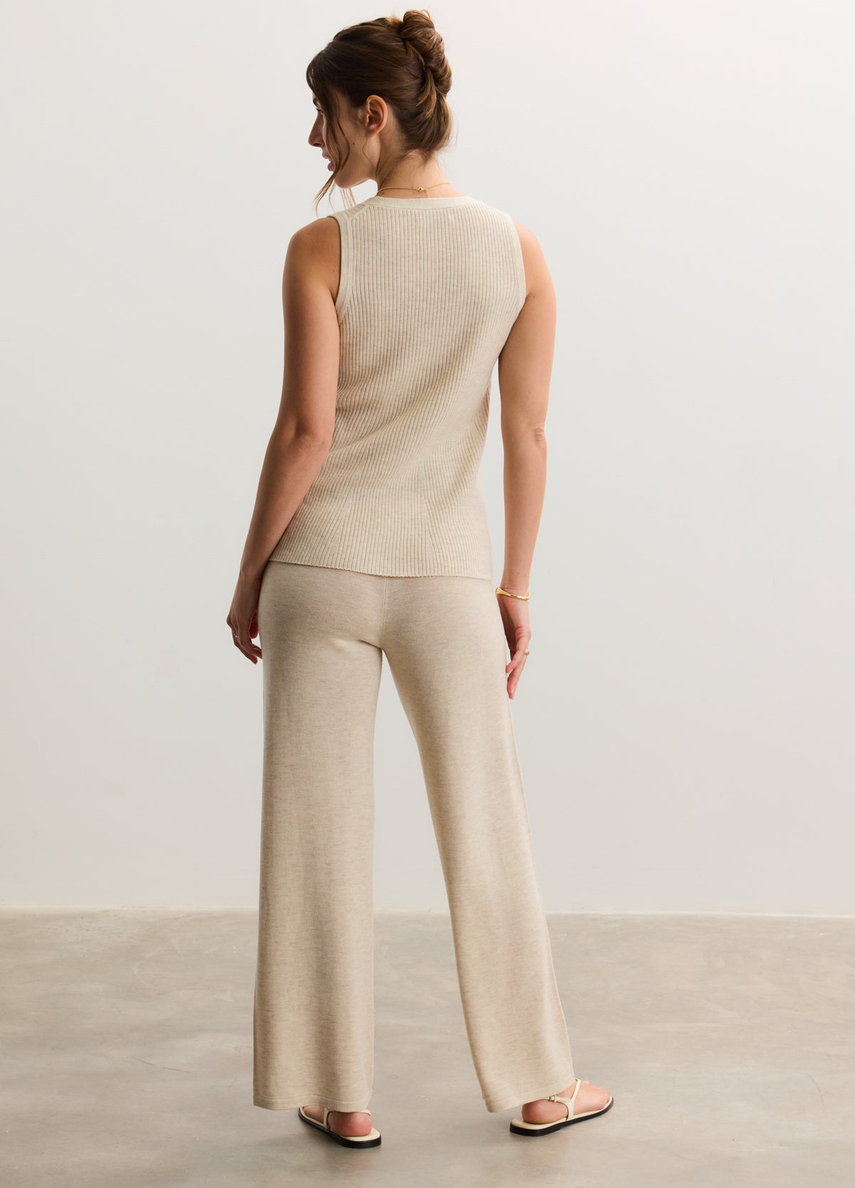 Beige knit maternity pants with wide legs, paired with a matching sleeveless knit top.