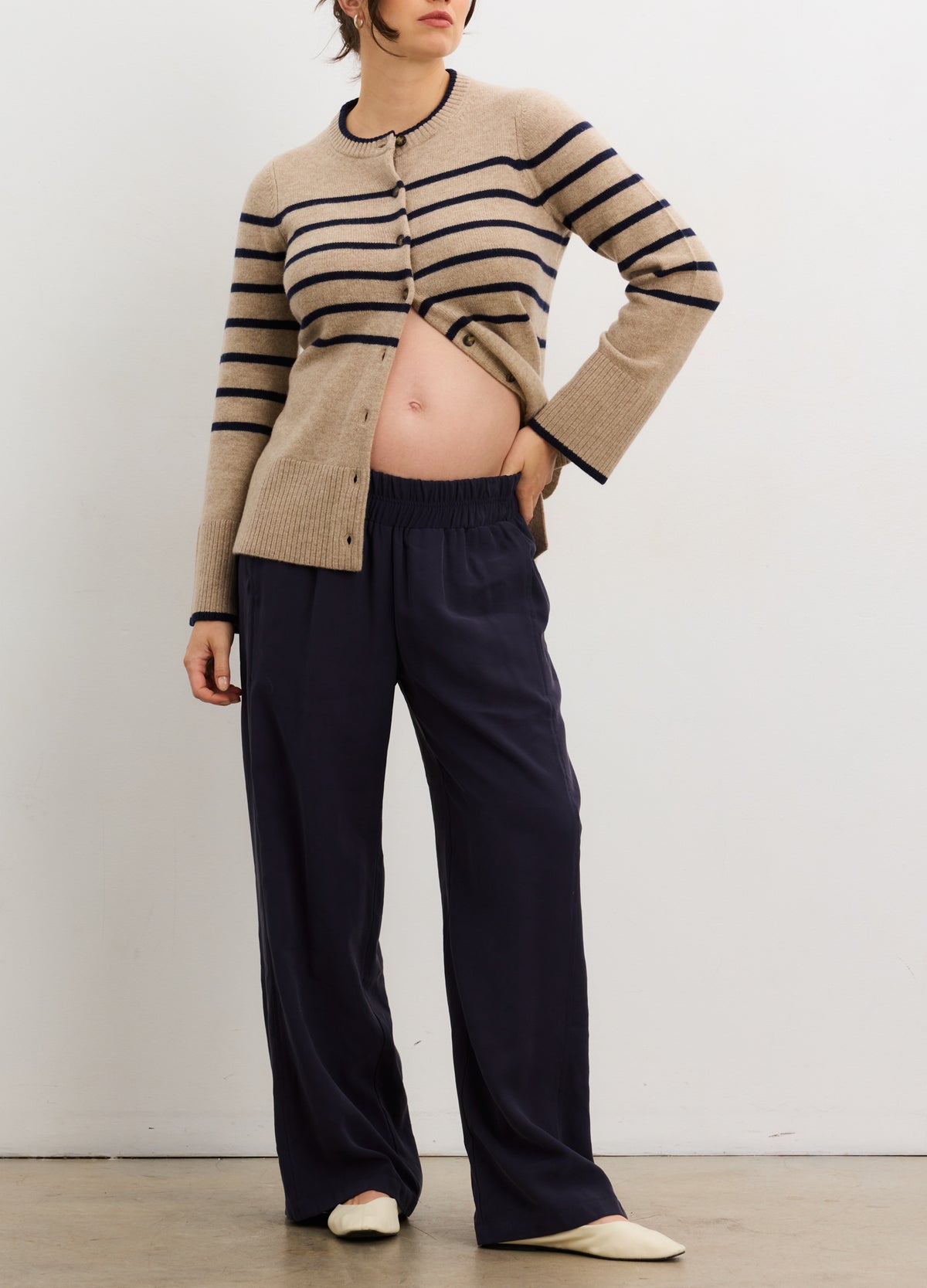 Beige and black striped cashmere cardigan with buttons, styled open over maternity wear.