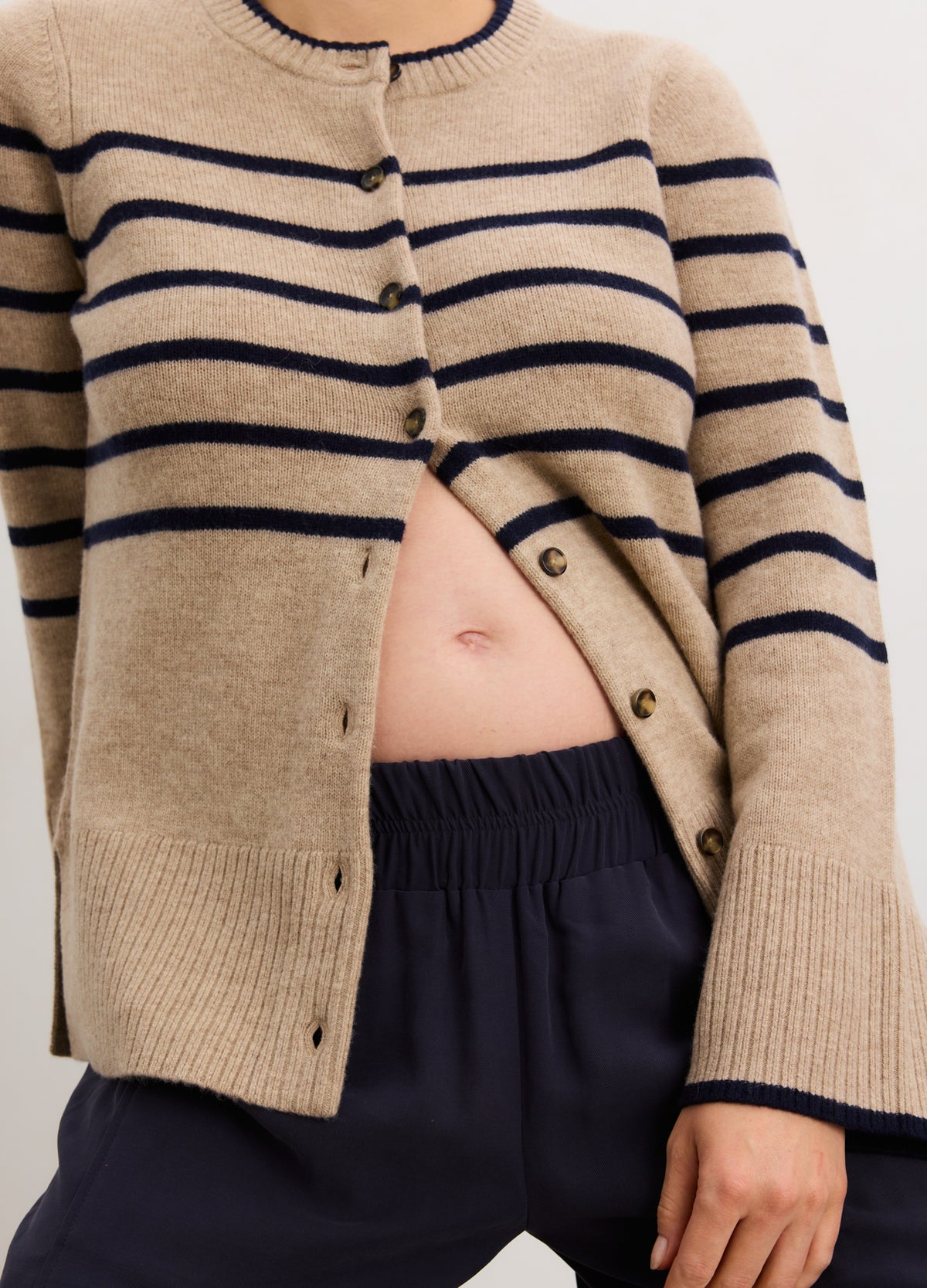 Beige cashmere cardigan with navy horizontal stripes, buttoned front, and round neckline designed for maternity wear.