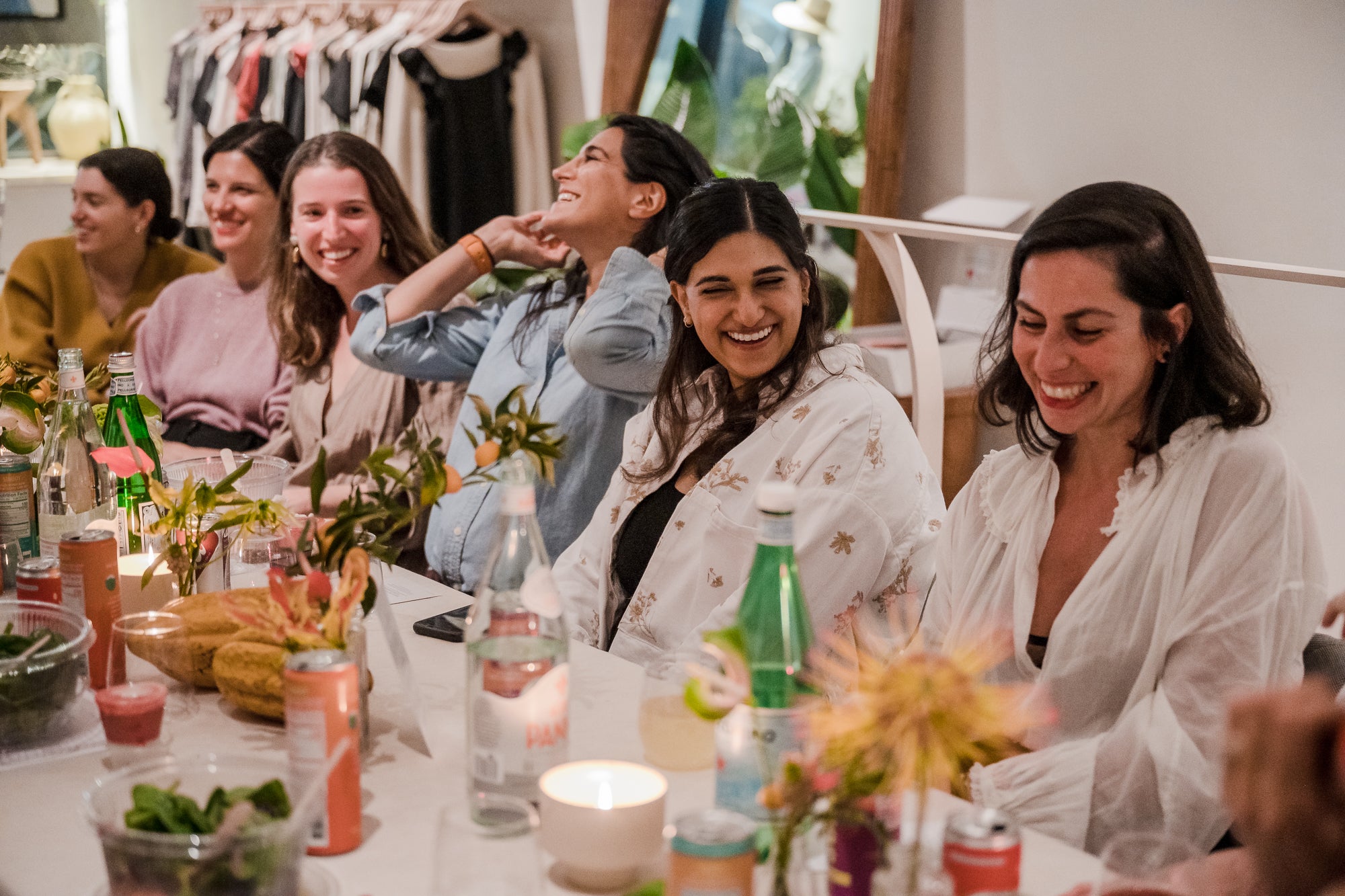Unbranded casual scene with five women sitting at a decorated dining table, dressed in light, comfortable clothing including