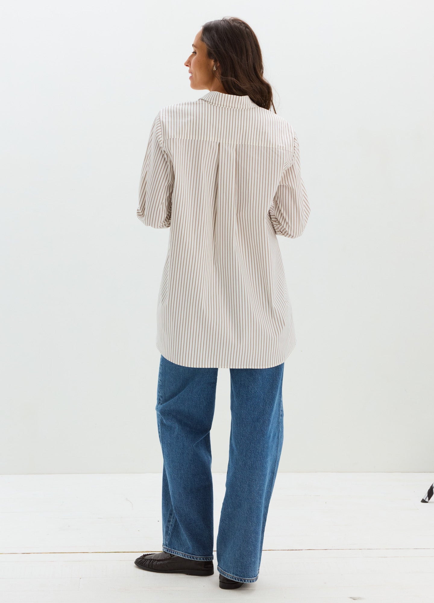 Light beige maternity buttondown shirt with short sleeves, loose fit, and pleated back detail.