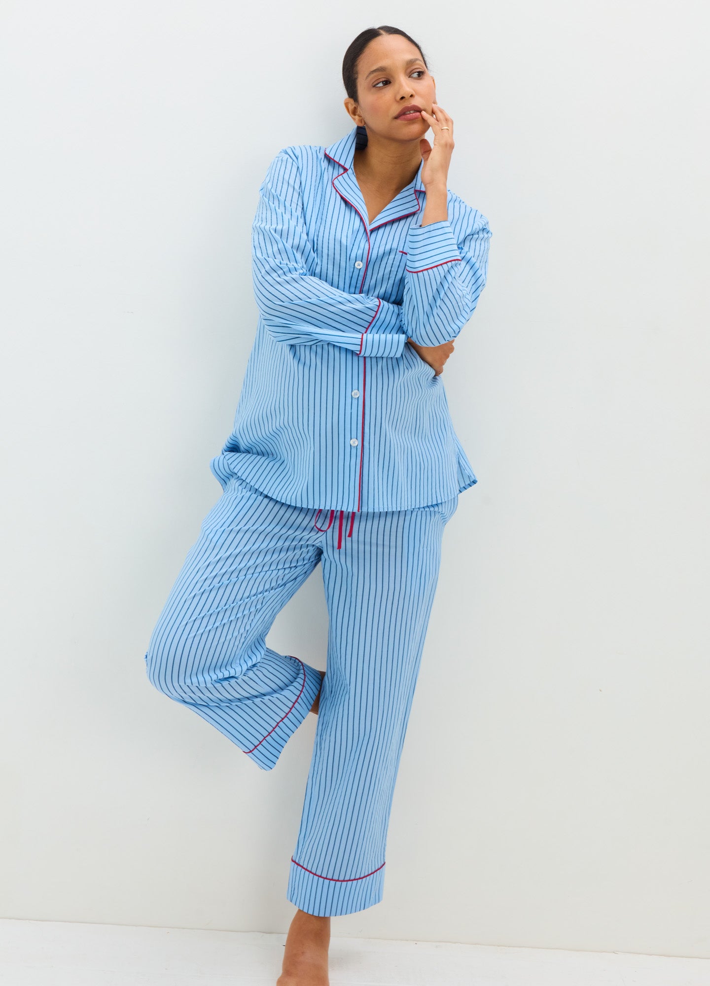 Light blue cotton maternity pajama set with long-sleeve button-up top and drawstring pants, pink piping detail.