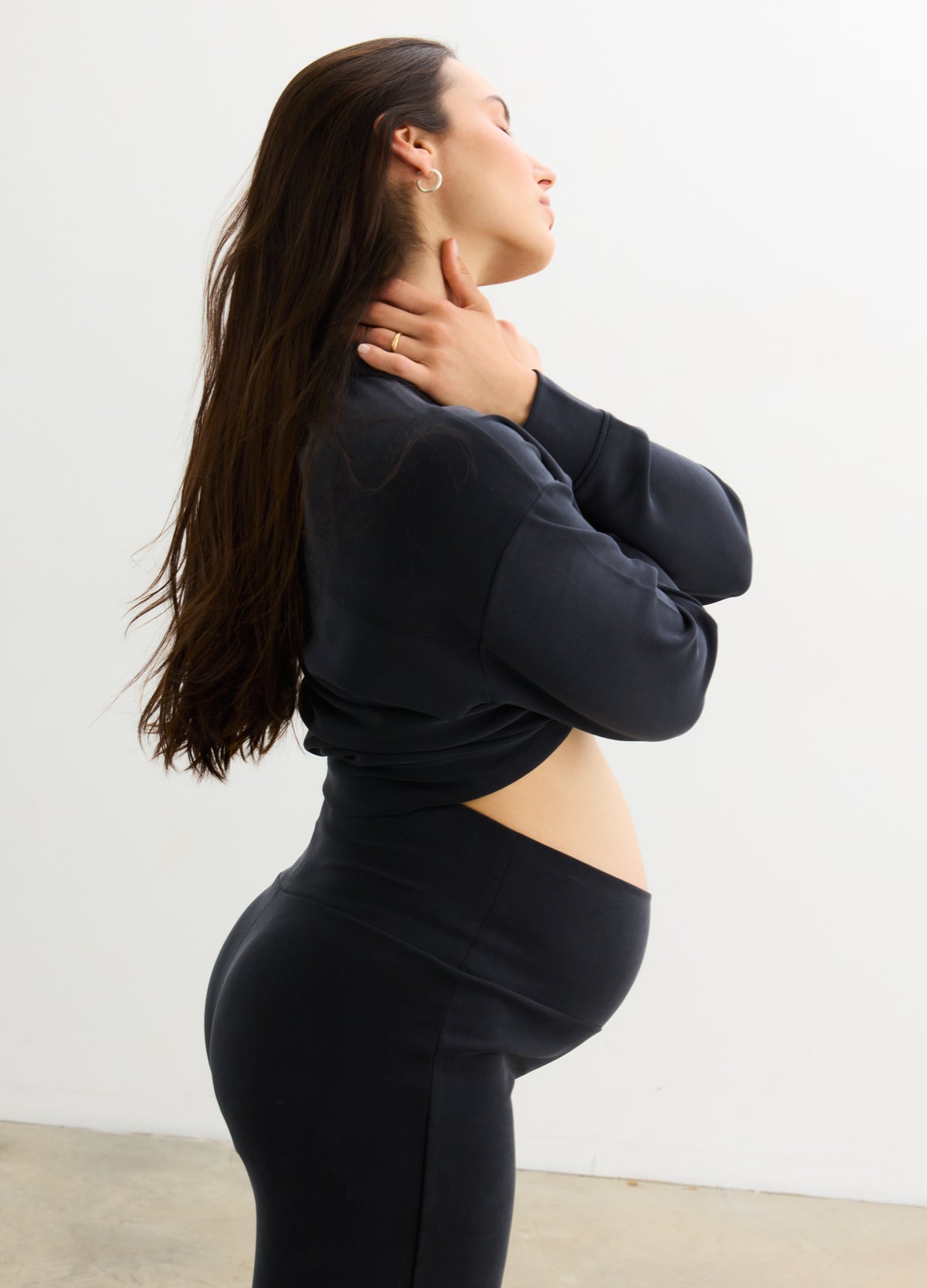 Black maternity leggings with high stretchy waistband supporting pregnant belly, smooth fabric.