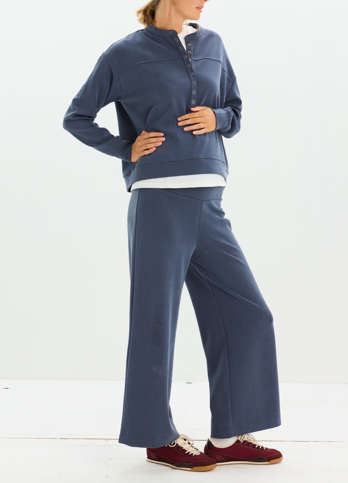 Navy blue maternity pullover with buttoned collar and matching wide-leg pants worn by pregnant model.