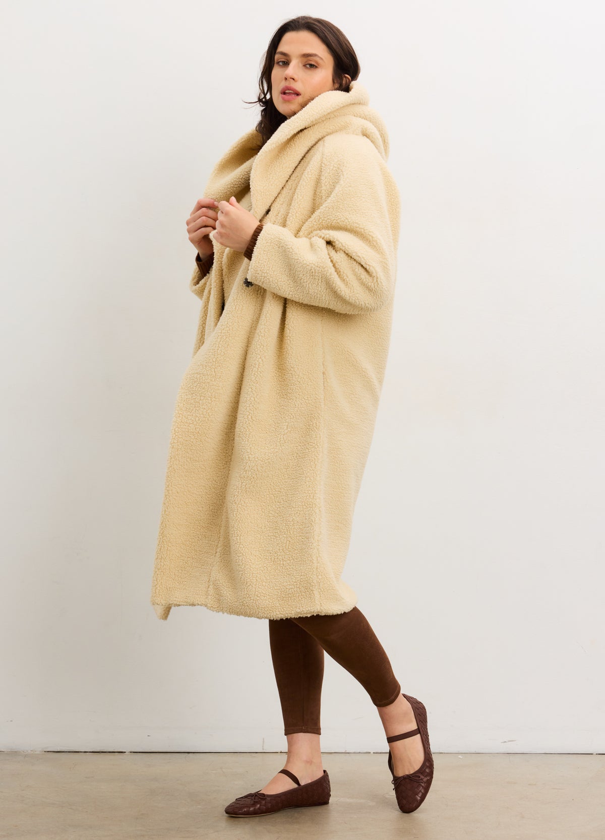 Warm vanilla shearling cocoon coat with oversized hood, designed for pregnant maternity wear.