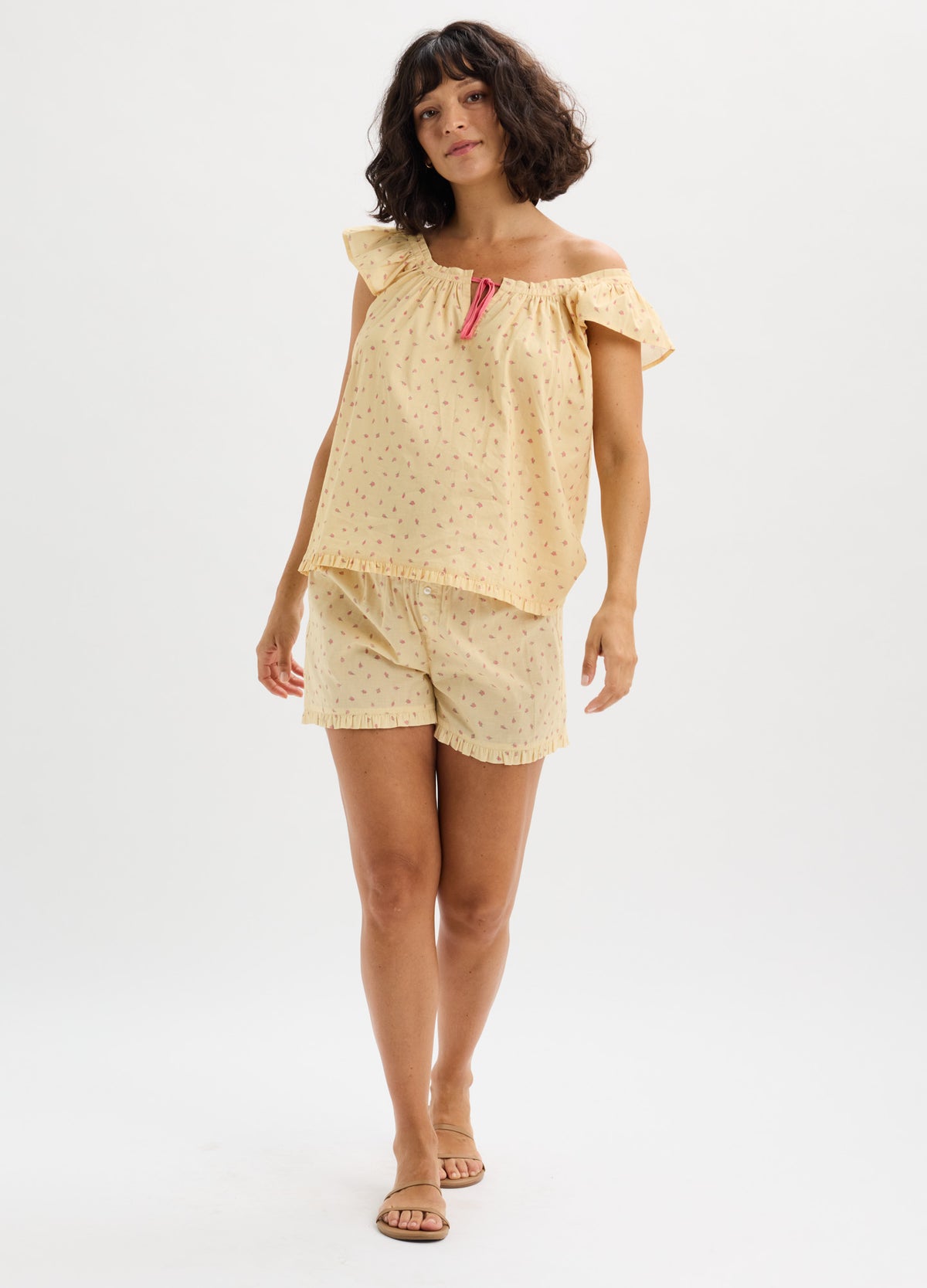 Light yellow cotton nursing pajama set with small floral print, ruffled off-shoulder tank, and relaxed shorts.
