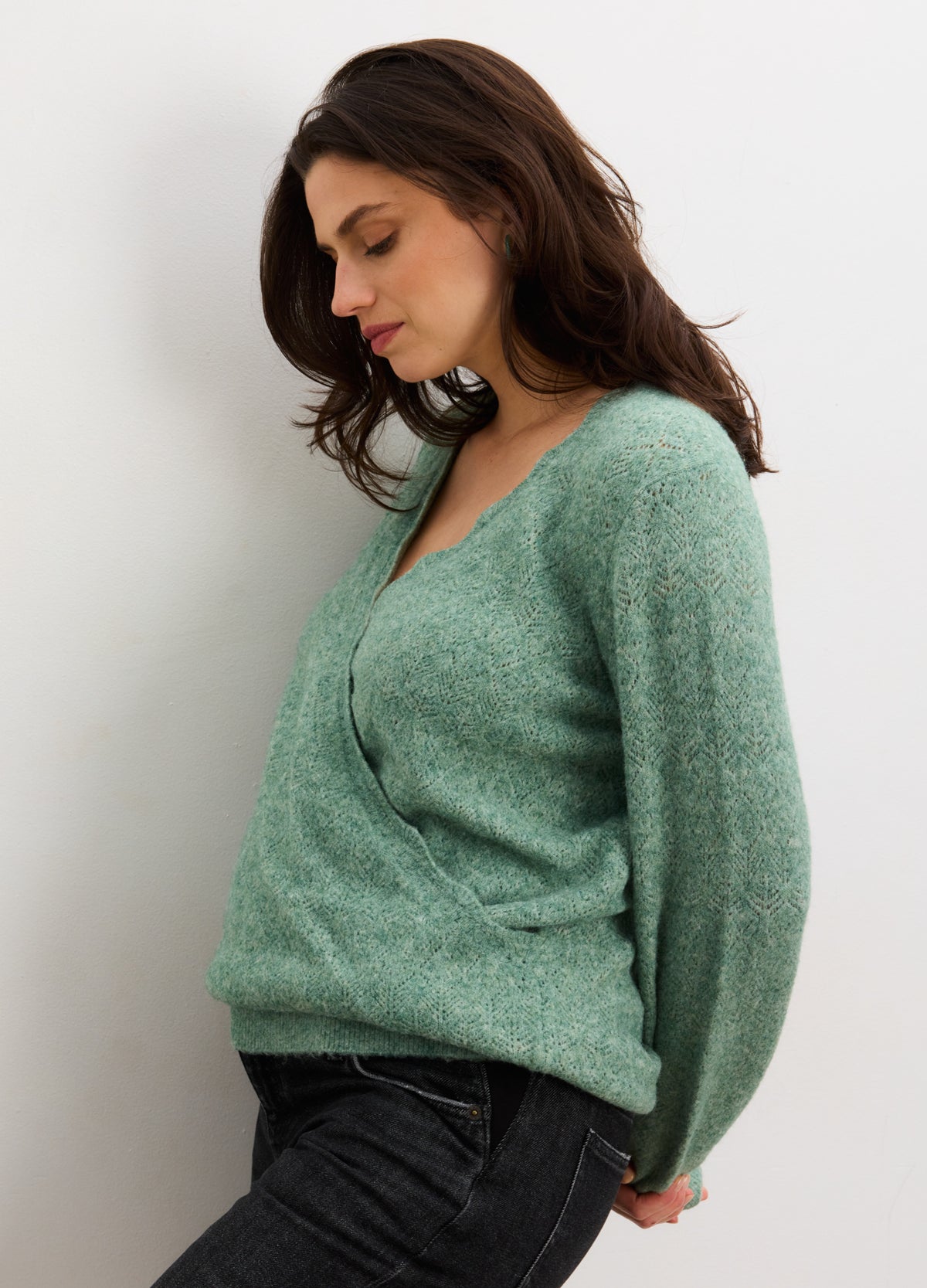 Soft matcha green maternity sweater with pointelle knit and relaxed fit, styled on pregnant model.