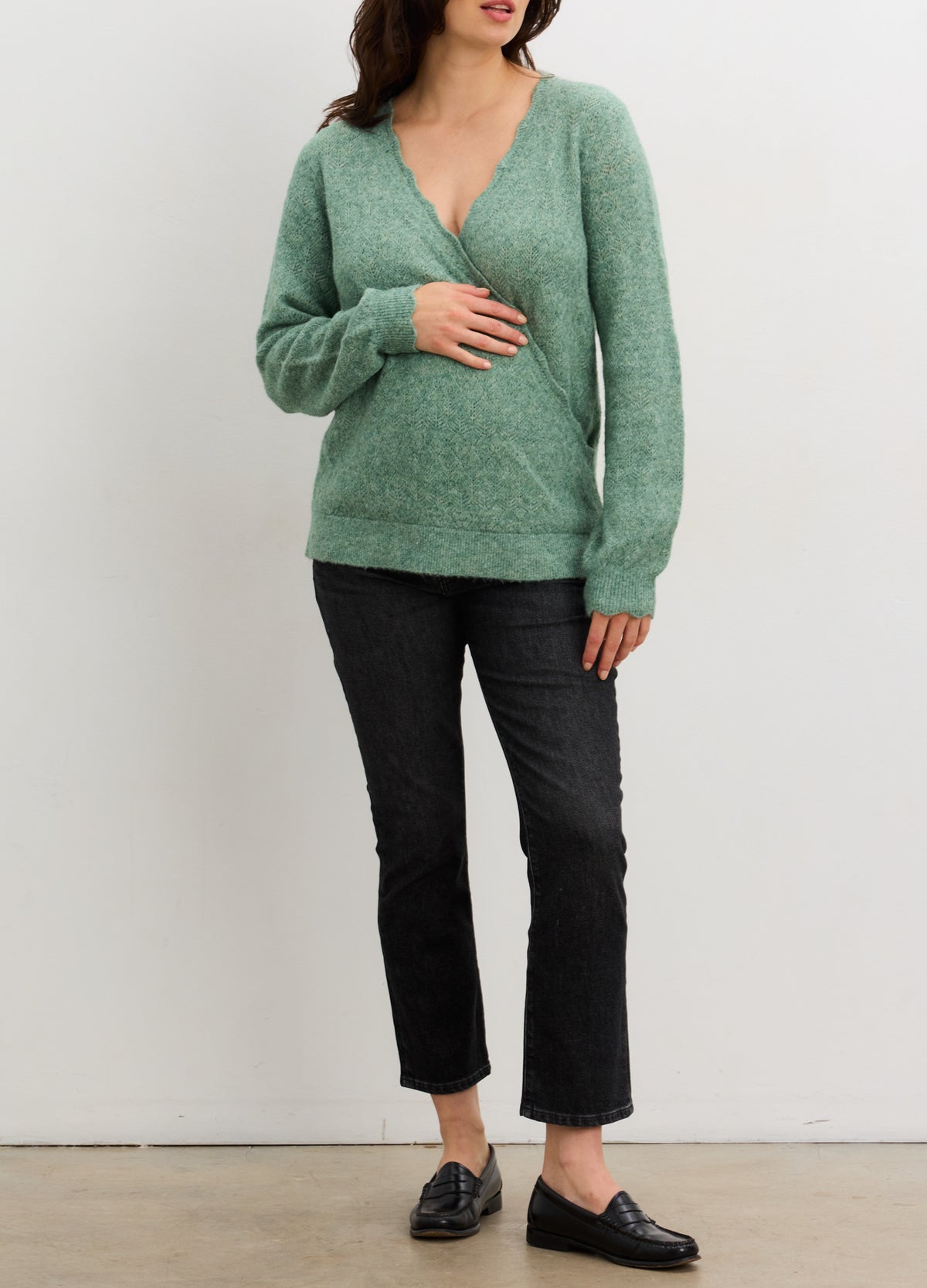 Soft green pointelle knit maternity sweater with V-neck and long sleeves.