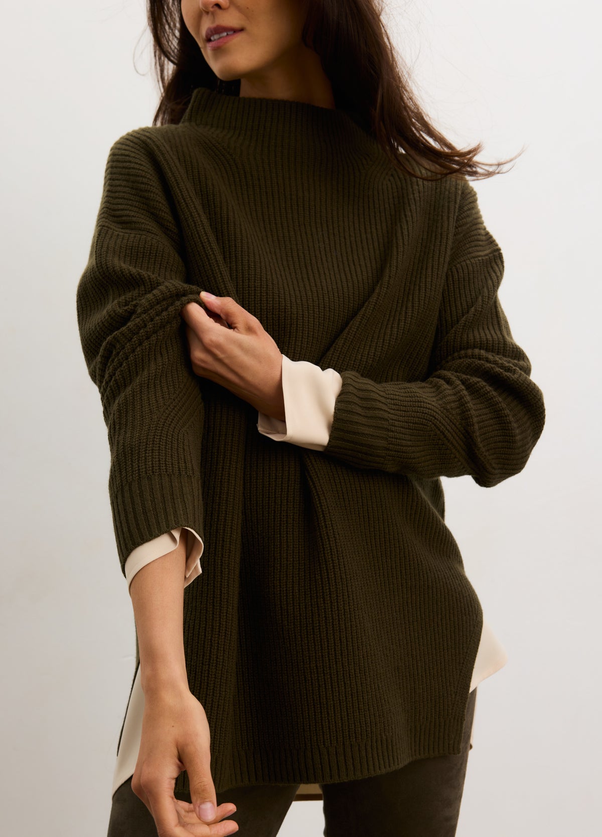Olive green ribbed maternity turtleneck sweater with relaxed fit on pregnant model.