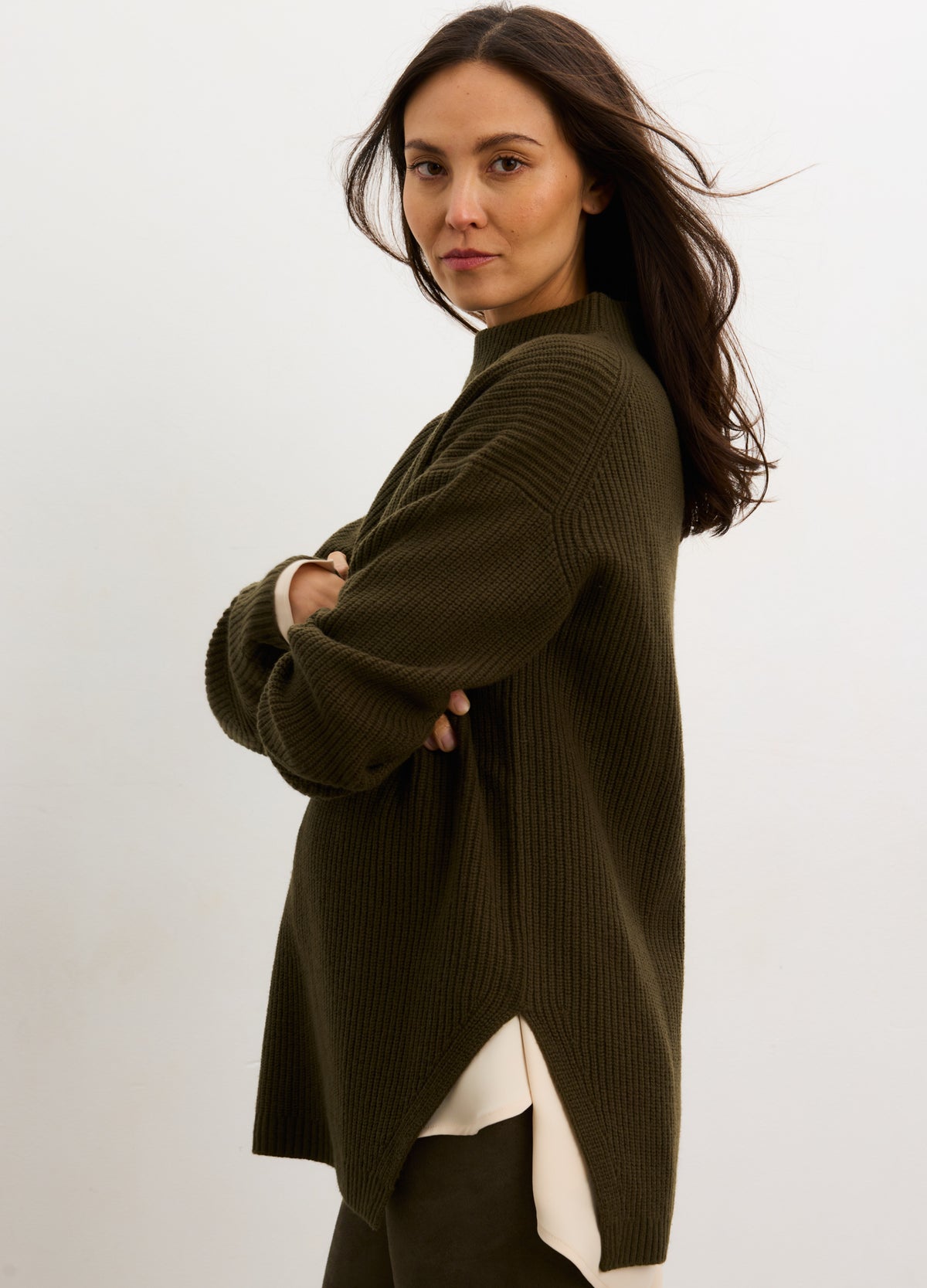 Olive green chunky knit turtleneck sweater with side slits, worn loose for maternity fit.