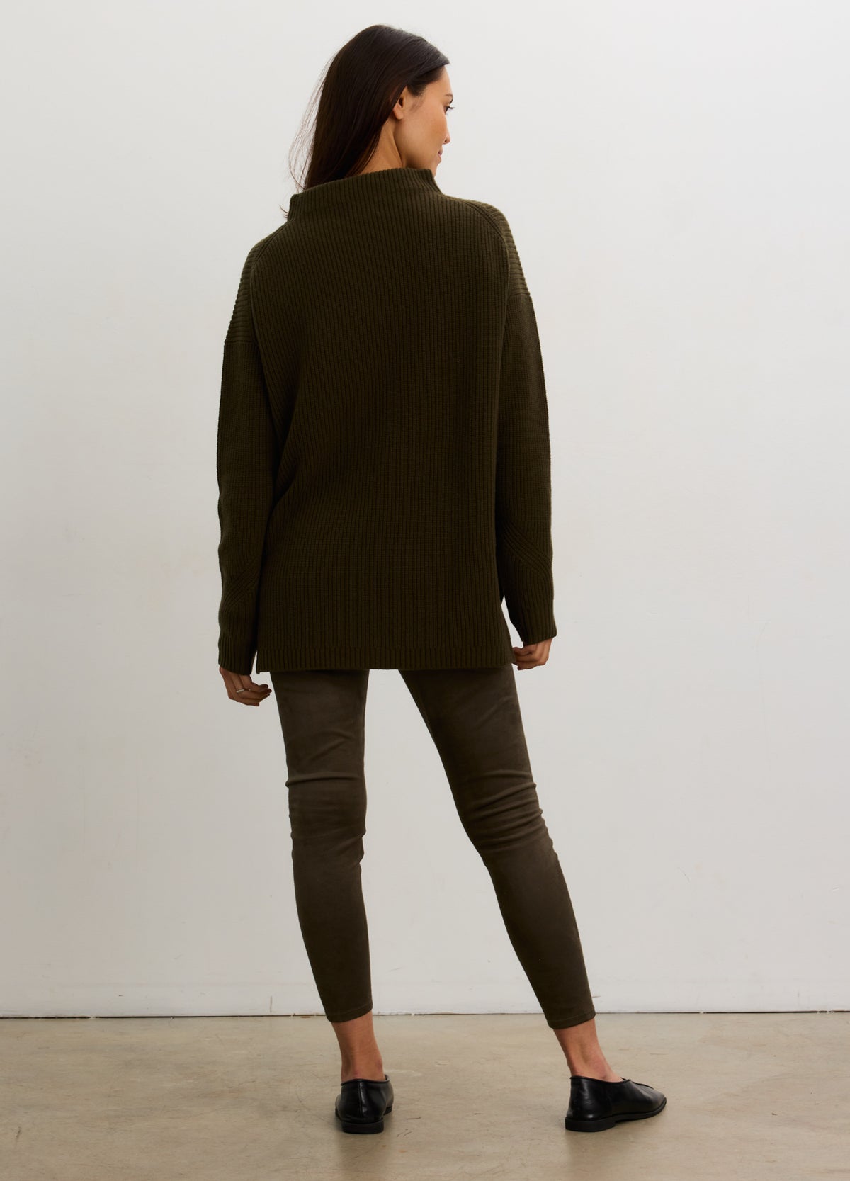 Dark olive green loose-knit turtleneck sweater with long sleeves, styled for maternity wear.
