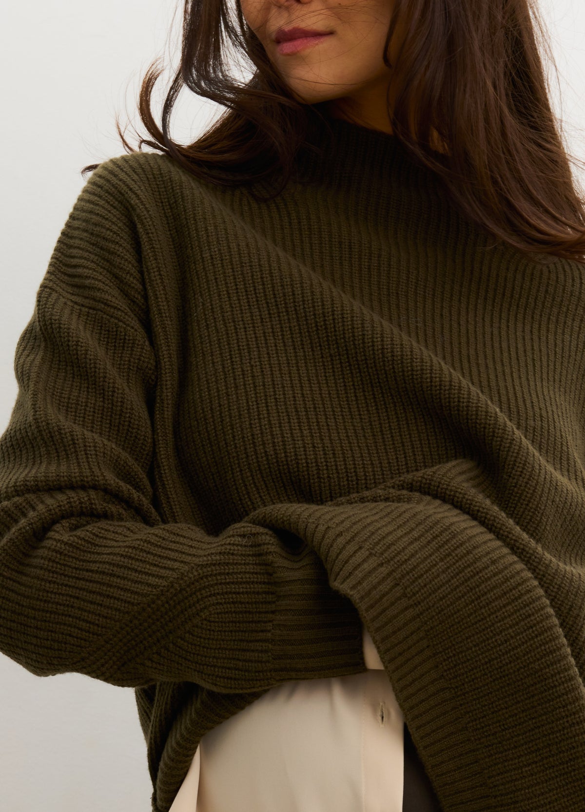 Olive green ribbed knit turtleneck sweater with relaxed fit and long sleeves.