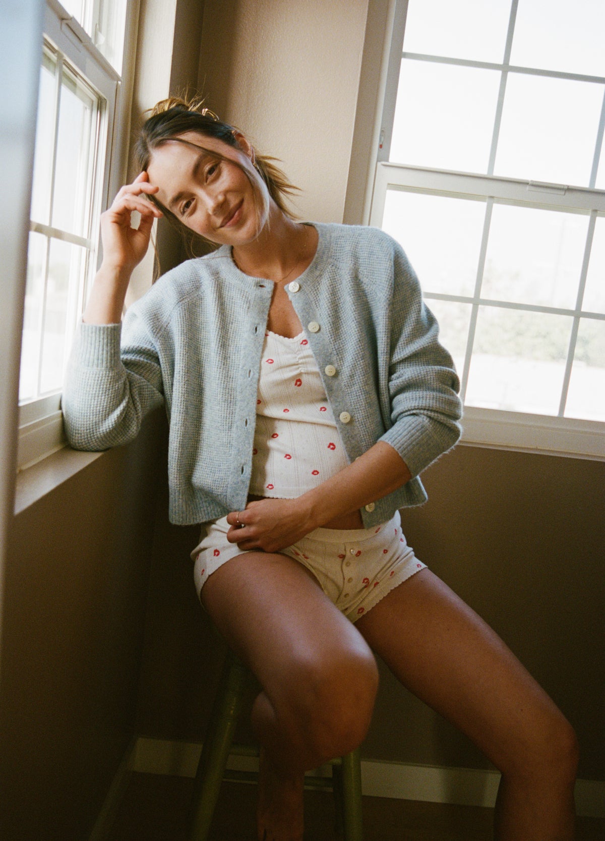 Light gray waffle-knit maternity cardigan with round neckline and button front, worn over floral maternity underwear.