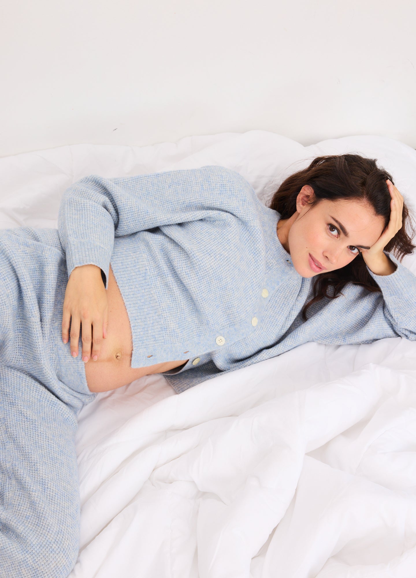 Light blue waffle knit cardigan with buttons, designed for maternity comfort and cozy fit.