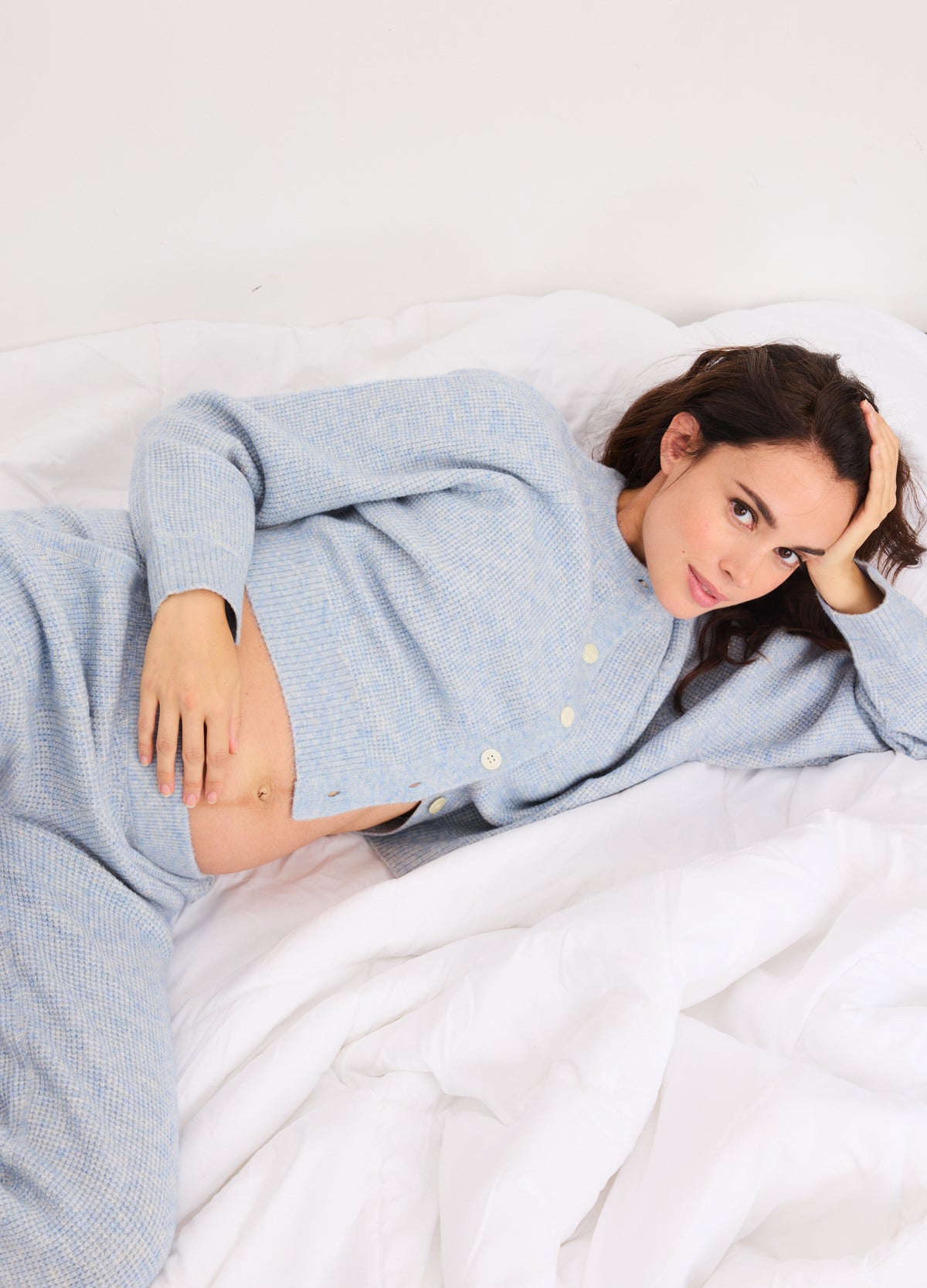 Light blue waffle knit cardigan with buttons, designed for maternity comfort and cozy fit.