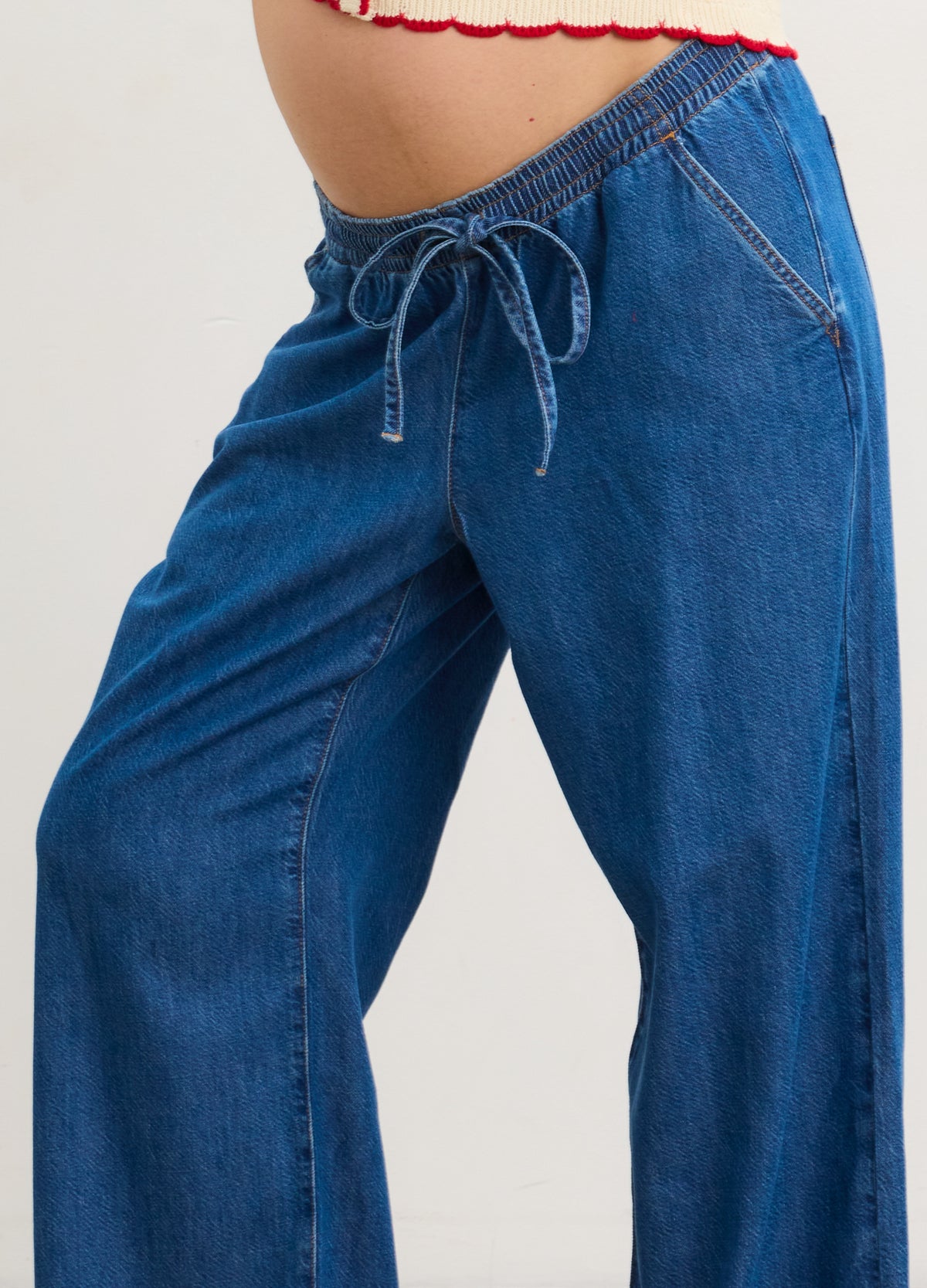 Blue denim wide-leg maternity pants with adjustable elastic waistband and drawstring tie.