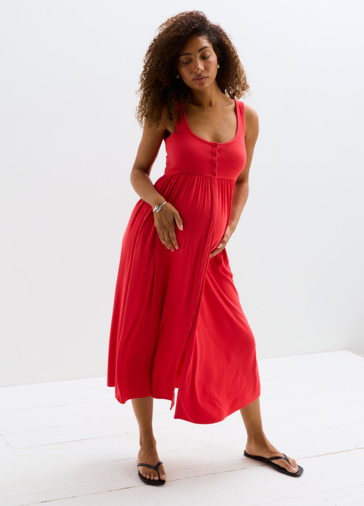 Red ribbed nursing tank dress with a front slit, sleeveless design, and relaxed fit for maternity comfort.