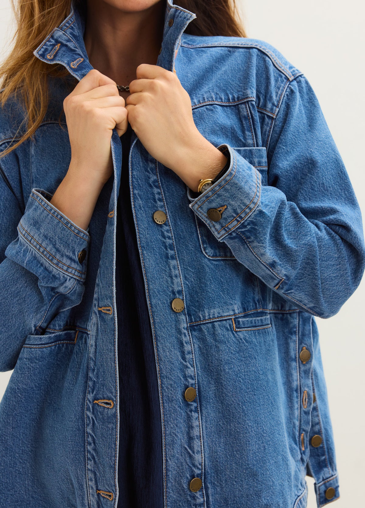 Blue denim maternity jacket with button front and relaxed fit designed for pregnant women.
