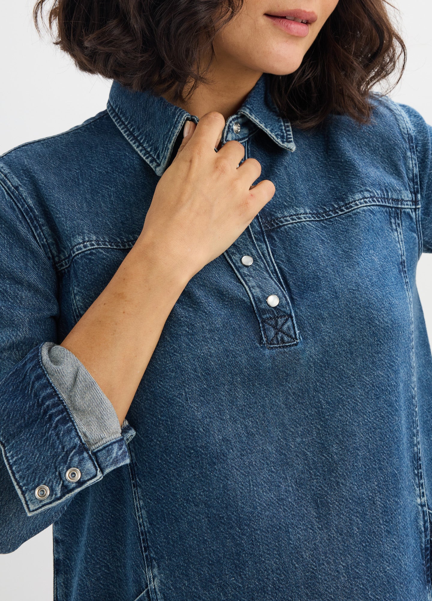 Blue denim maternity mini dress with long sleeves, buttoned collar, and relaxed fit.