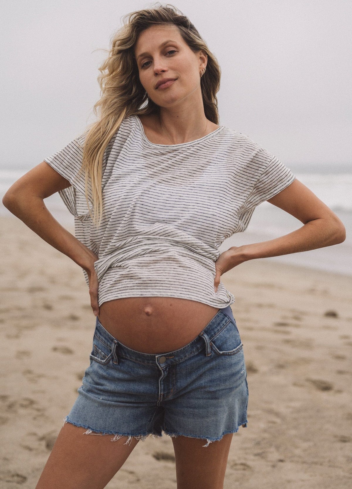 The Cut Off Maternity Short - Indigo denim maternity shorts with stretchy side panels for pregnancy, nursing, and postpartum comfort.