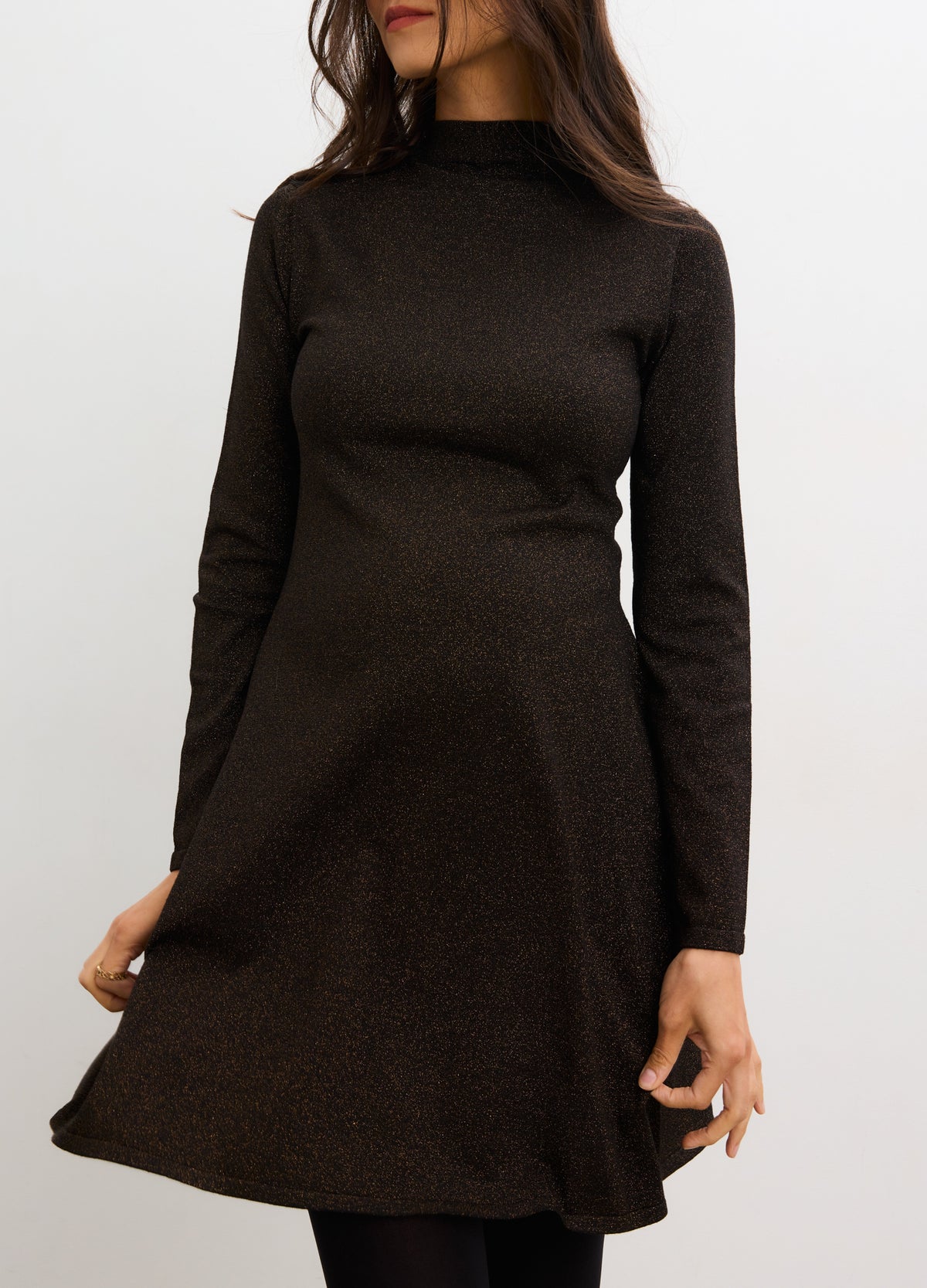 Black metallic knit mini dress with long sleeves and high neckline, flattering maternity fit.