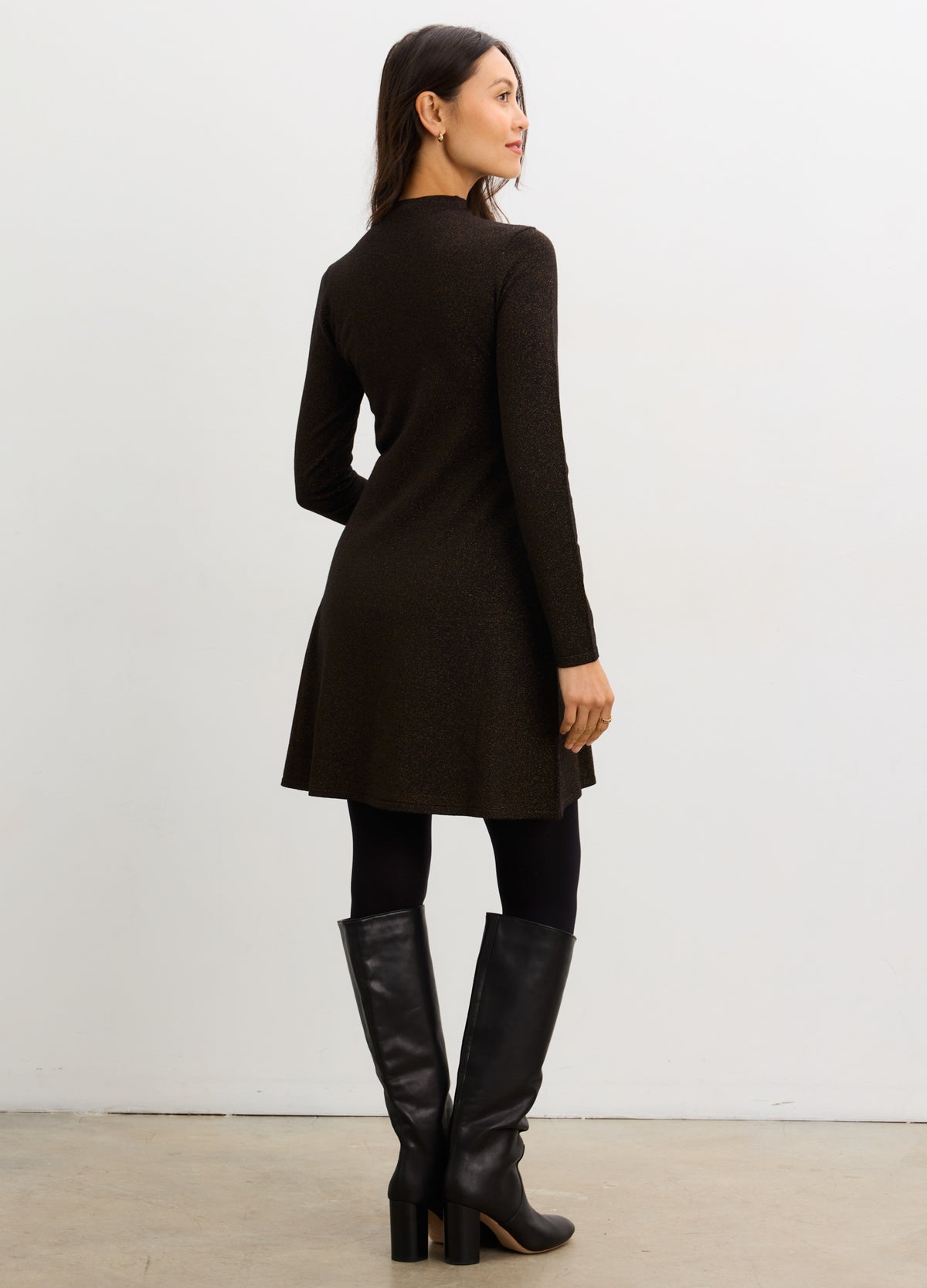 Black long-sleeve knit mini dress with A-line silhouette, styled for maternity wear.
