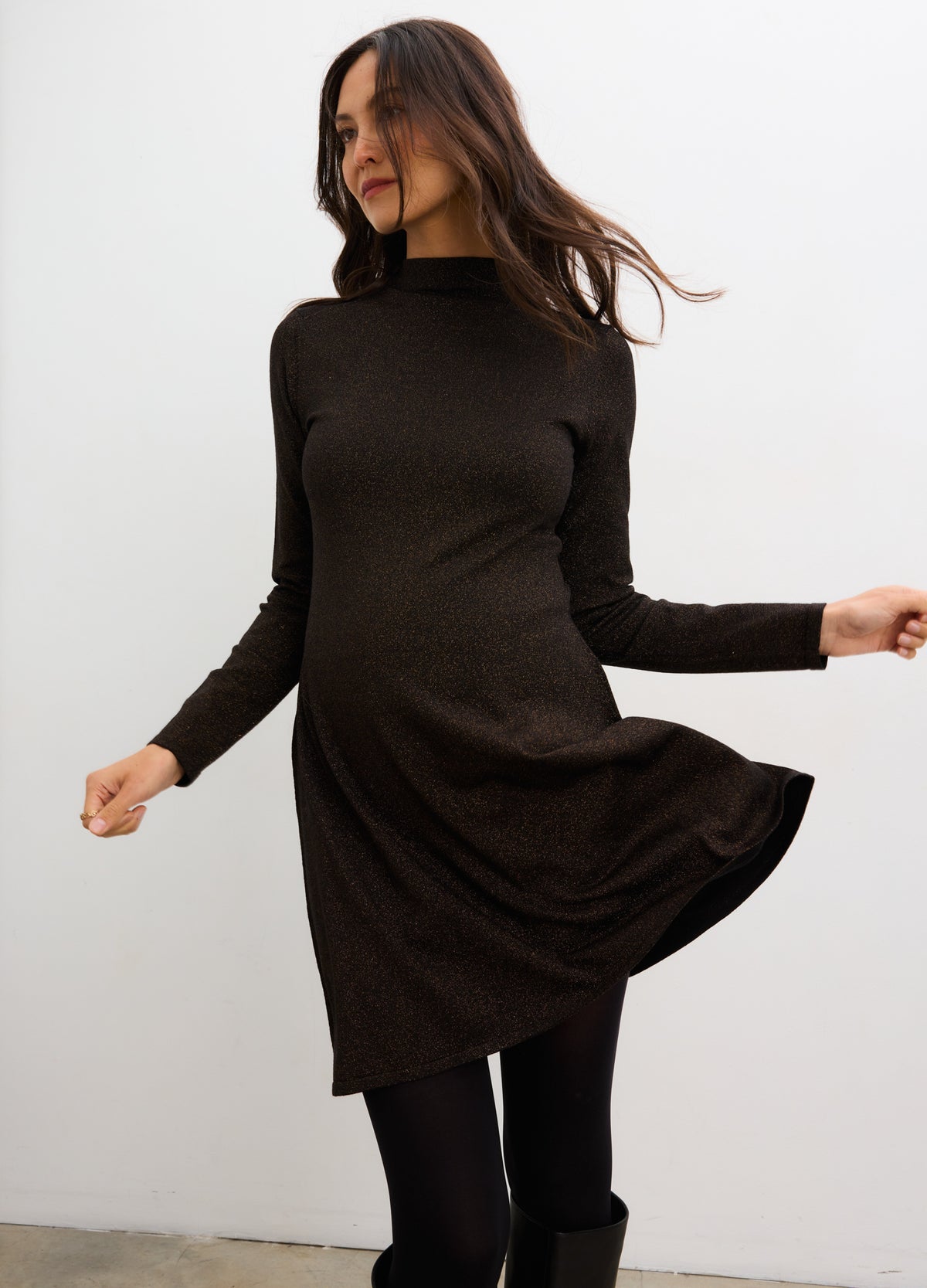 Black metallic knit mini dress with long sleeves and mock neck, designed for maternity wear.
