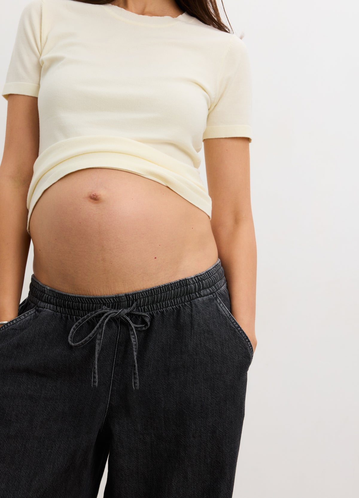 Black wide leg denim maternity pants with adjustable drawstring waist and relaxed fit.