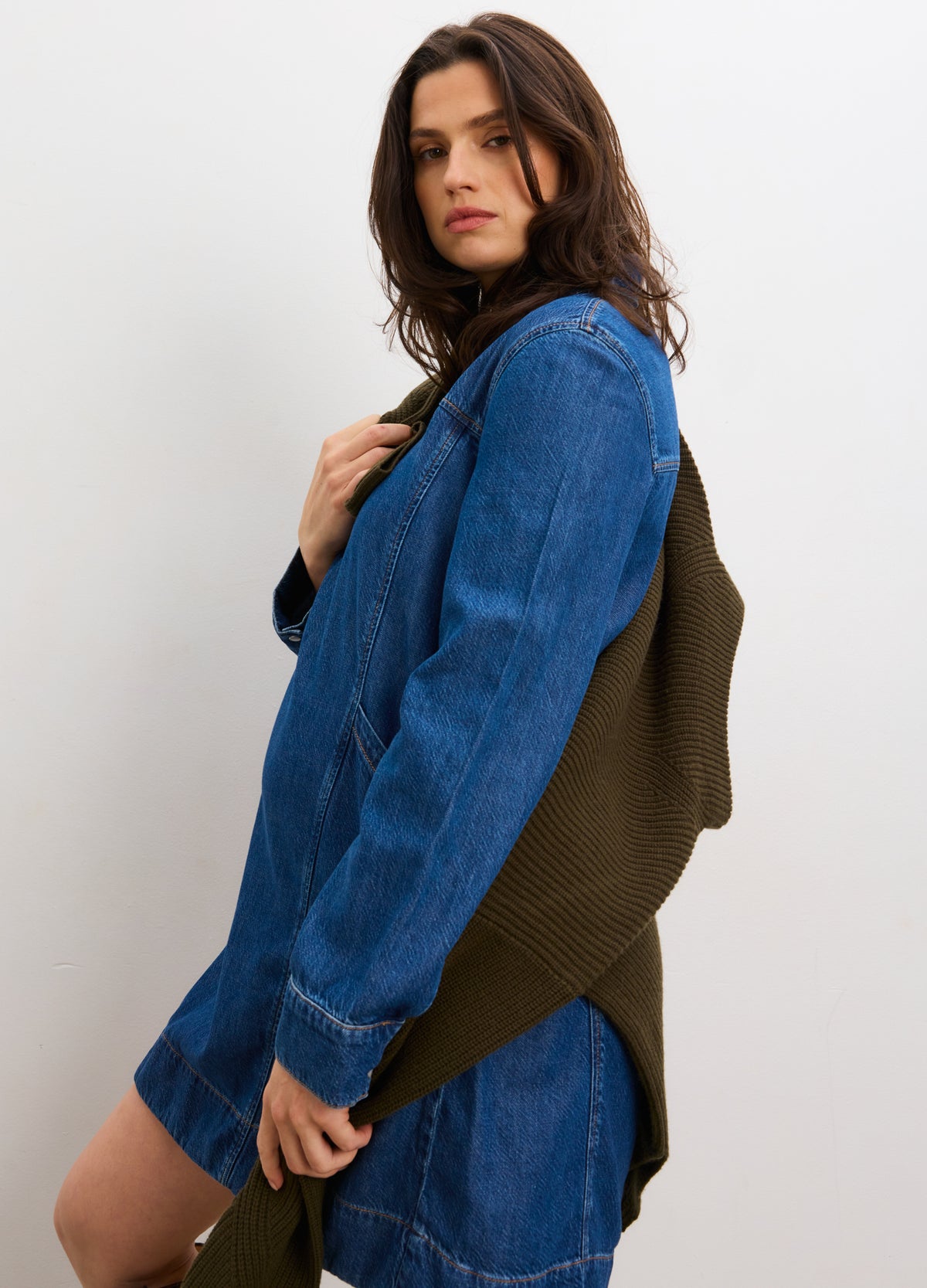 Blue denim mini dress with long sleeves and relaxed fit, styled for maternity wear.