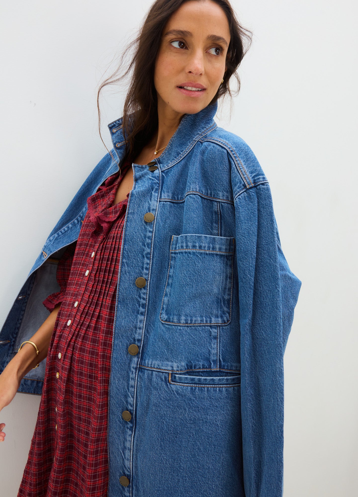 Blue denim utility jacket with large patch pockets, worn open over red maternity dress.